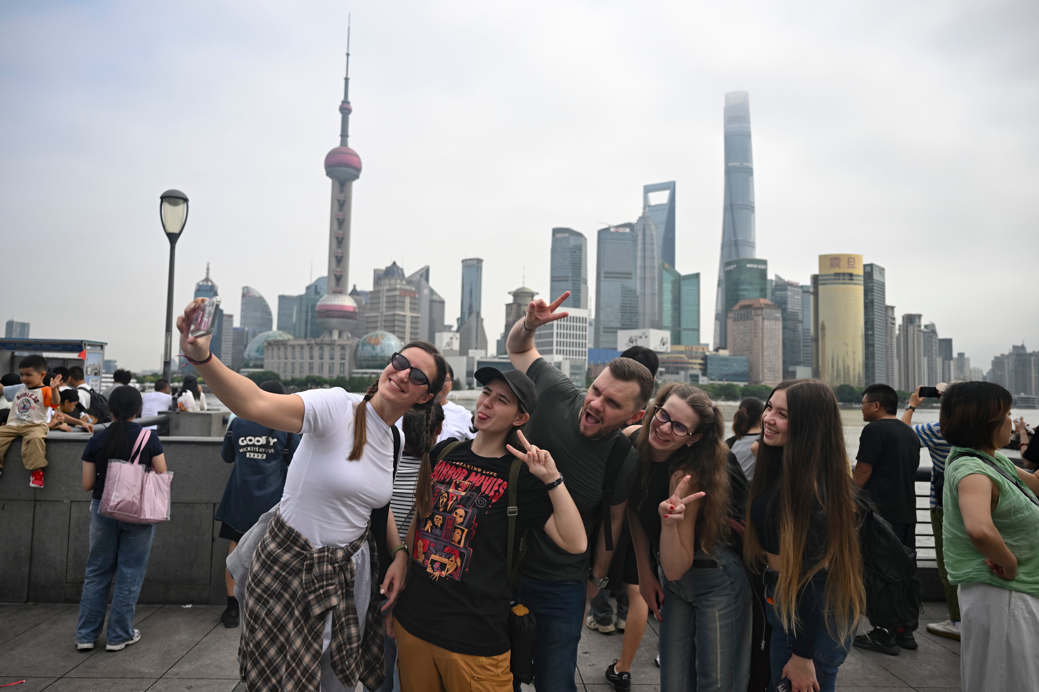 Tourists from Russia take a selfie at the Bund area in Shanghai. Photo: Xinhua