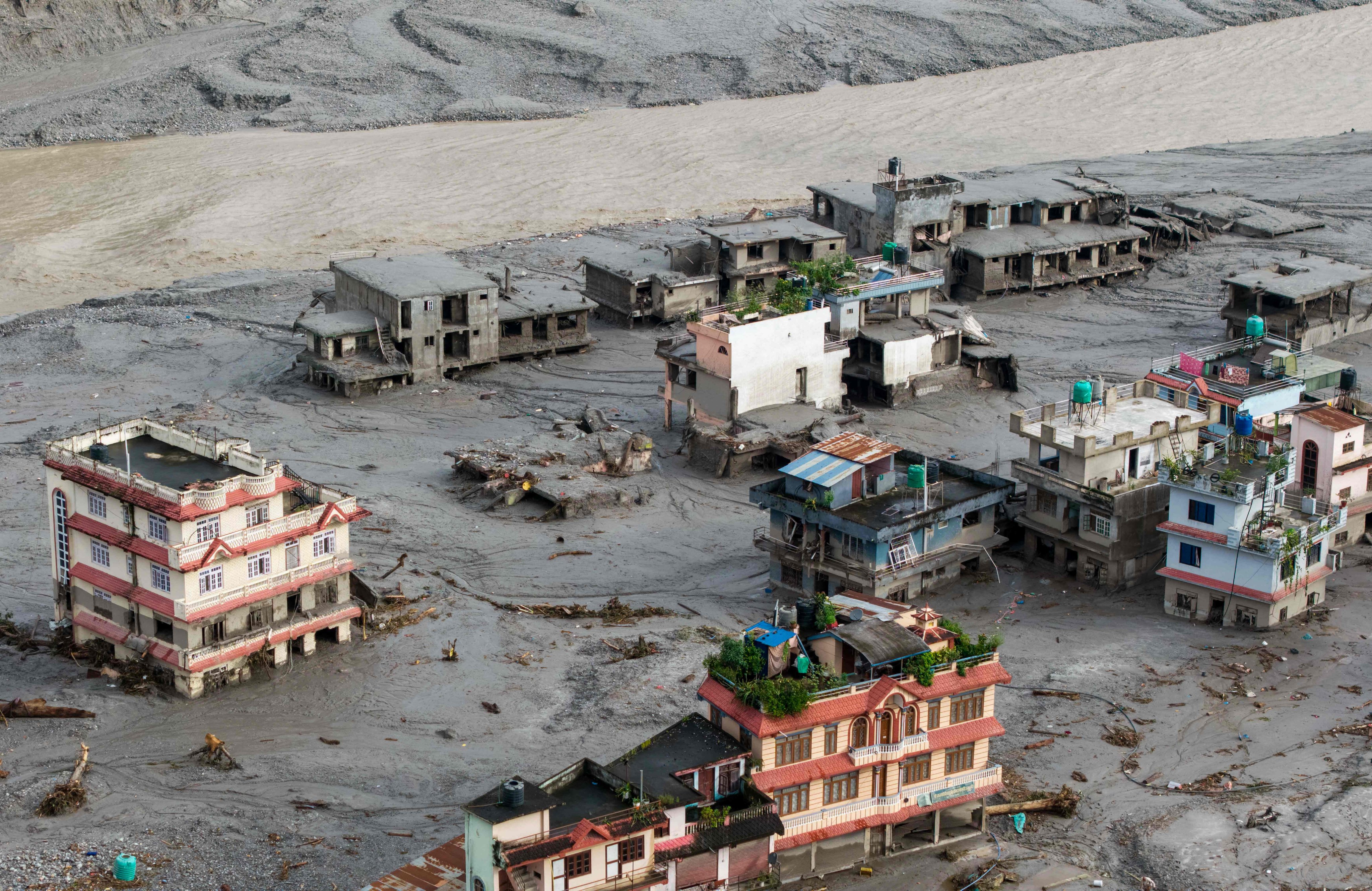 An aerial view shows houses lying deluged in sludge after flash floods at Devighat in Nepal’s Nuwakot district on August 27. Photo: AFP