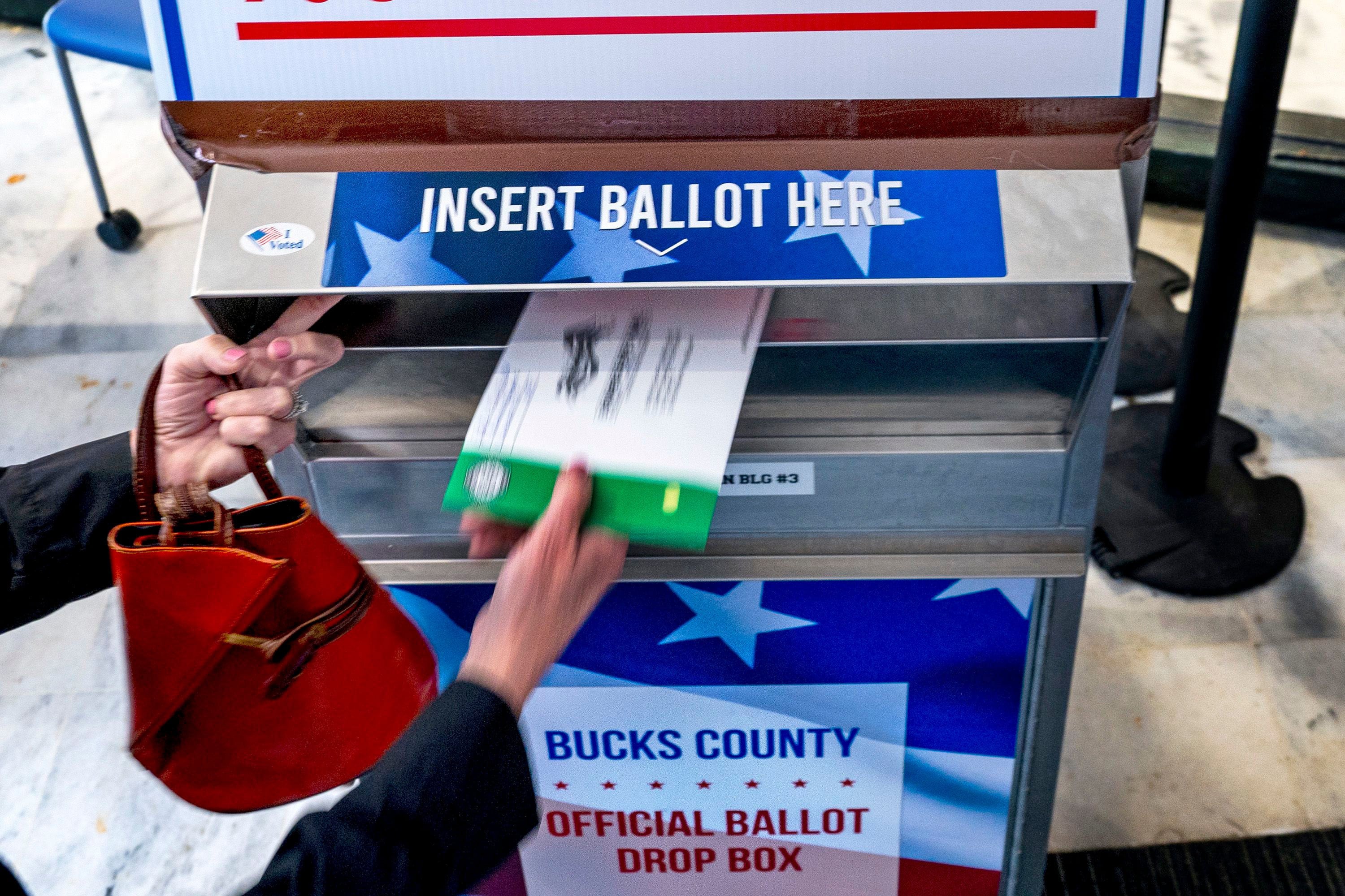 A voter places a mail ballot into a drop box. About 30 per cent of Americans vote by mail, according to state election data. Photo: TNS