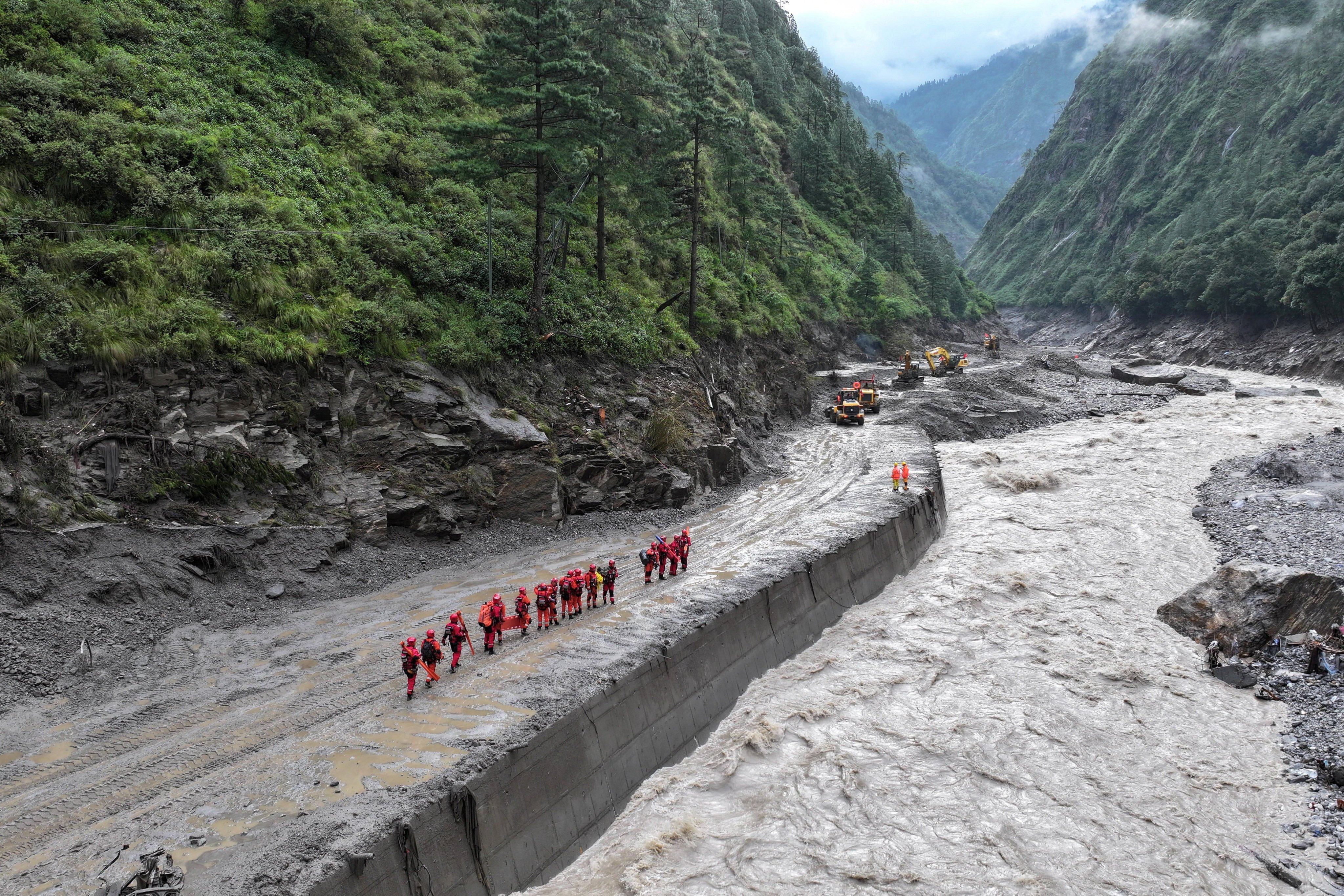 Firefighters pictured on a damaged road in Gyirong county, Tibet. Photo: Reuters