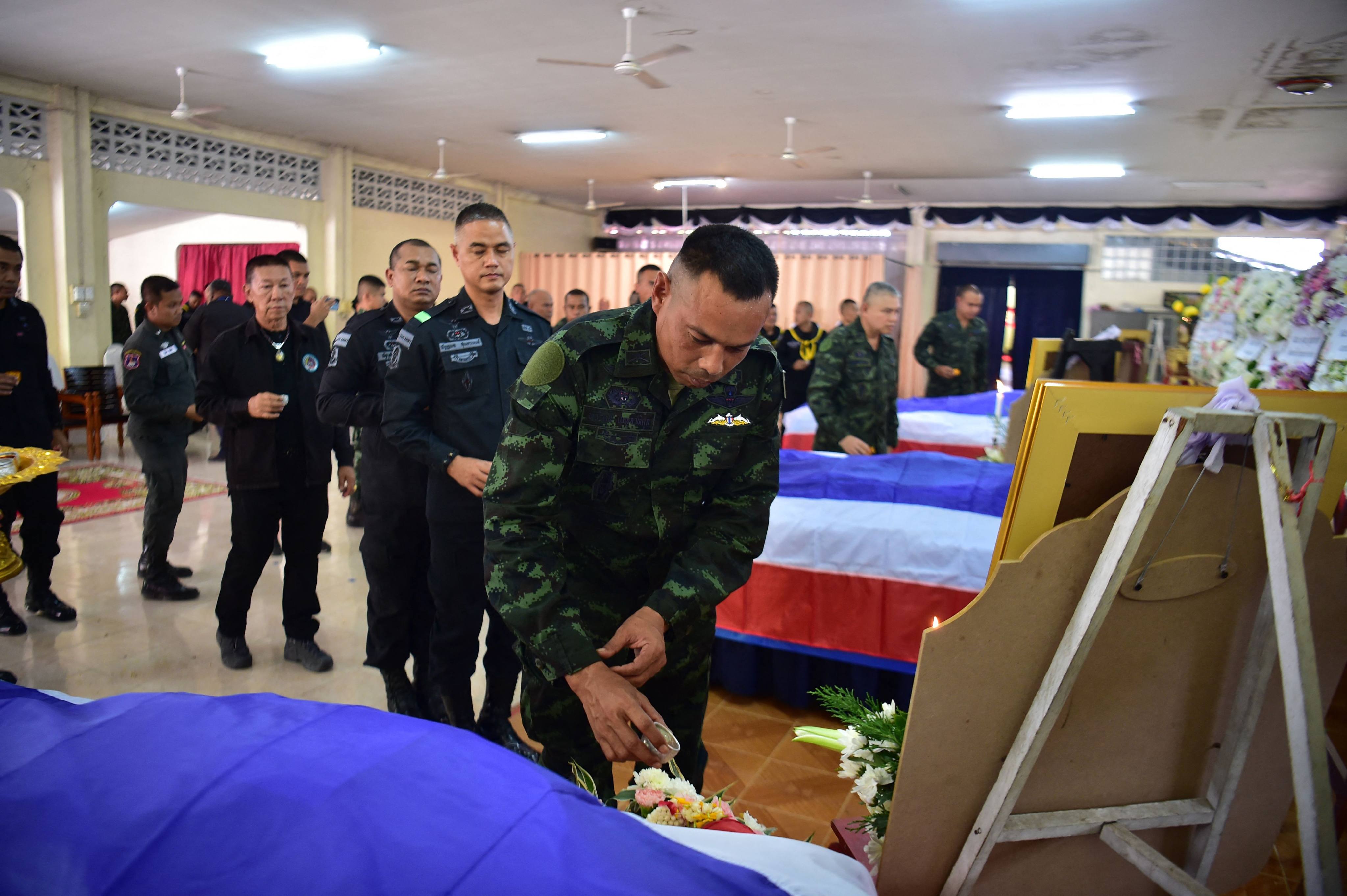 Thai soldiers pay respects next to the coffins of soldiers killed at a checkpoint in Thailand’s restive south, in the southern Narathiwat province in July. Photo: AFP