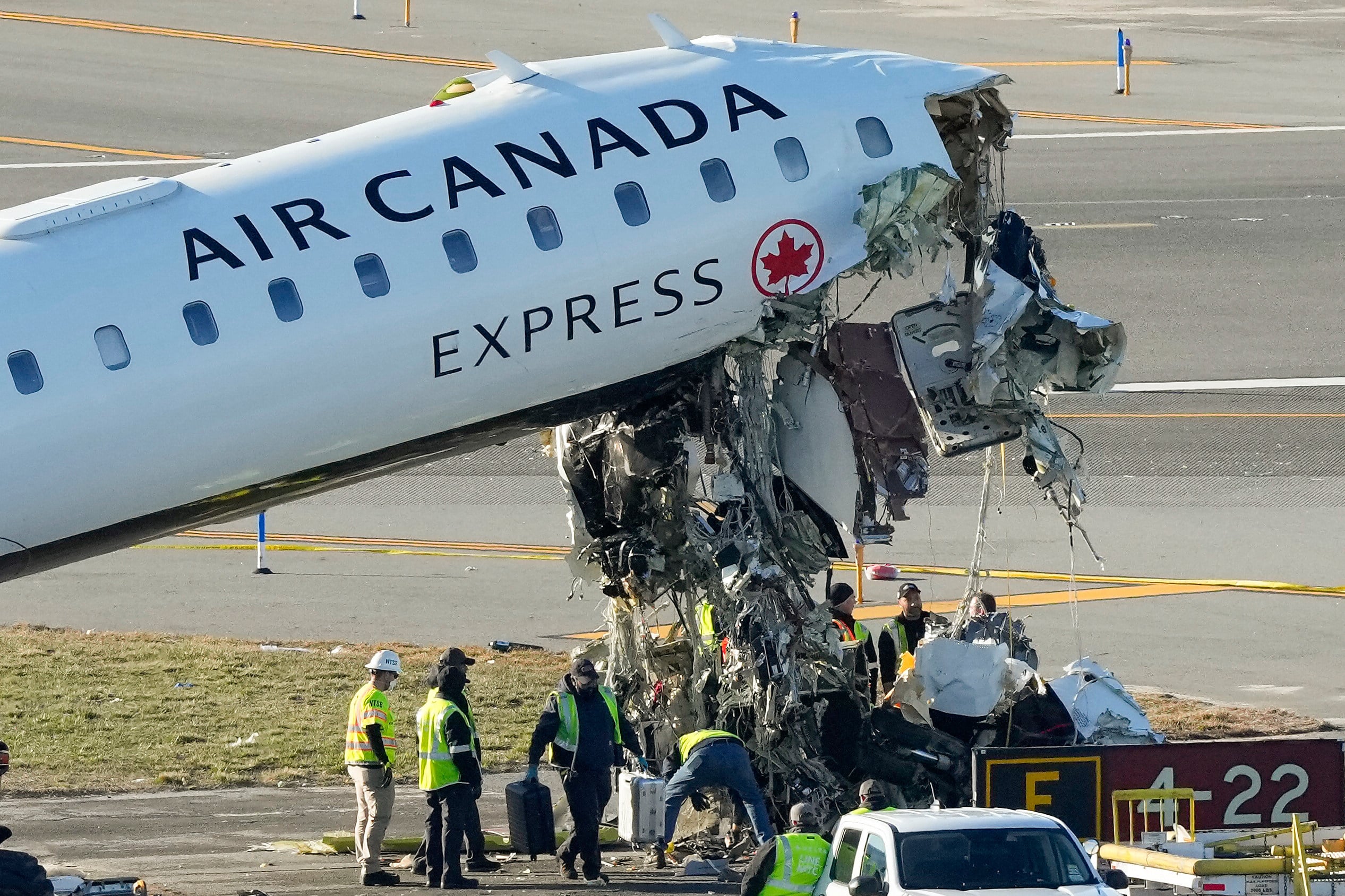 Officials and aircraft maintenance workers pick through debris and remove luggage as they inspect the wreckage of an Air Canada Express jet at LaGuardia Airport in March. Photo: AP