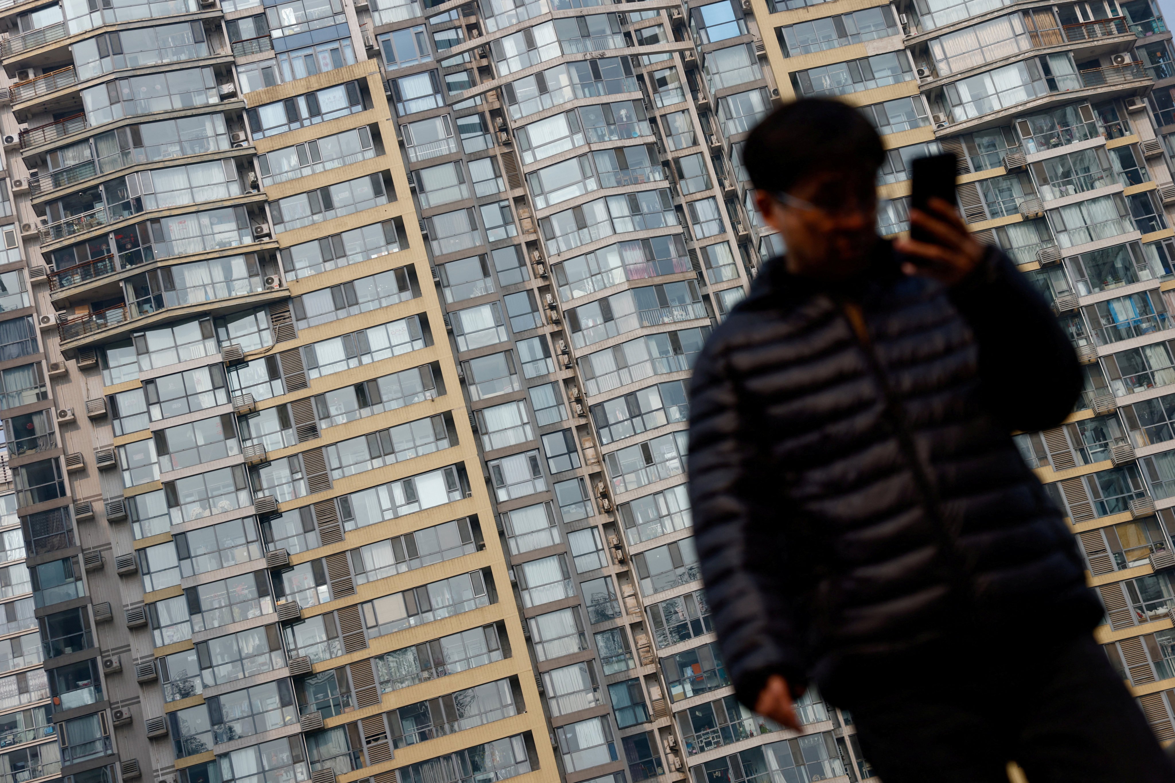 A man walks on an overpass near residential buildings in Beijing. Photo: Reuters