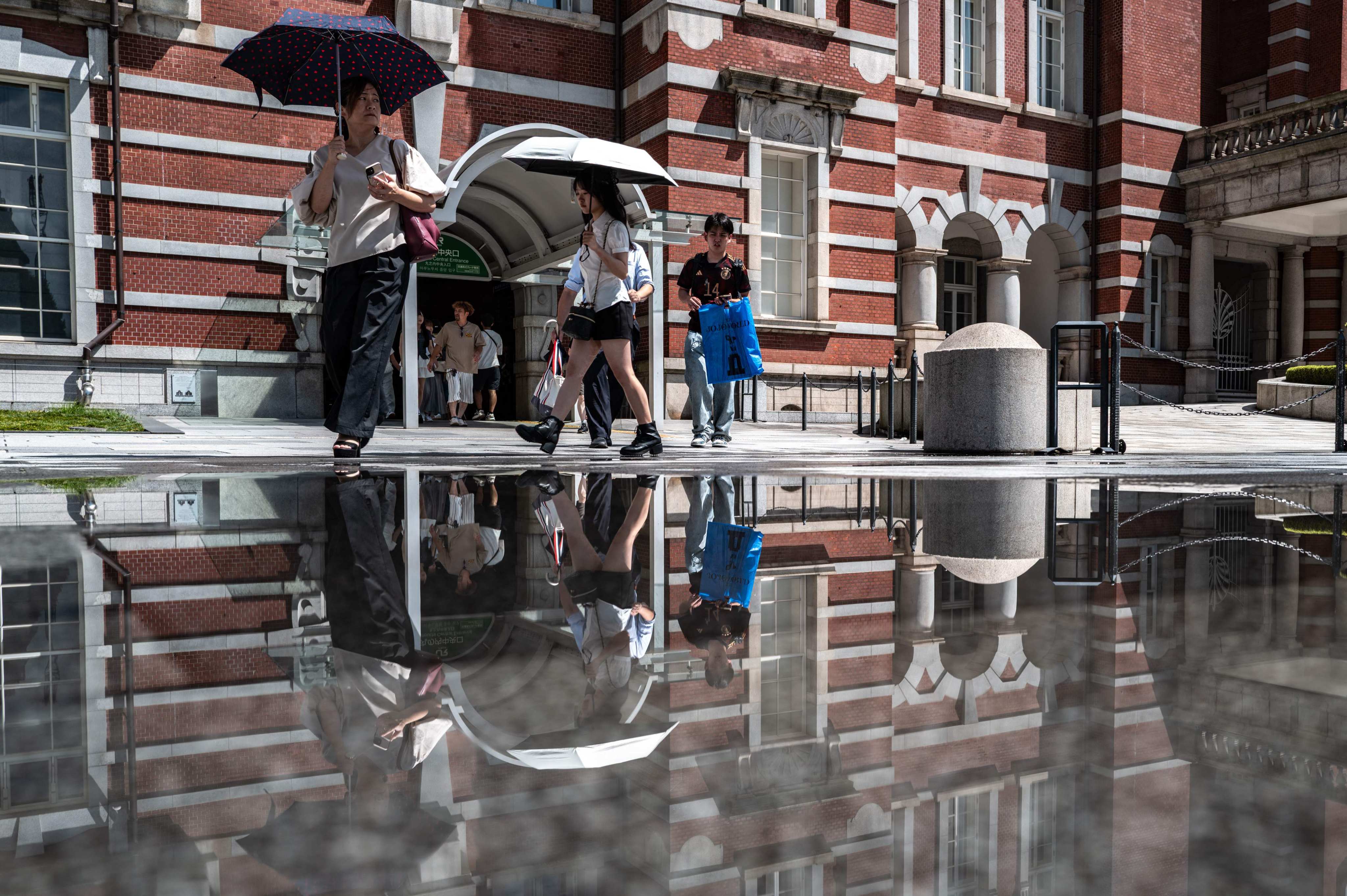 Commuters walk outside Tokyo Station on August 12. Photo: AFP