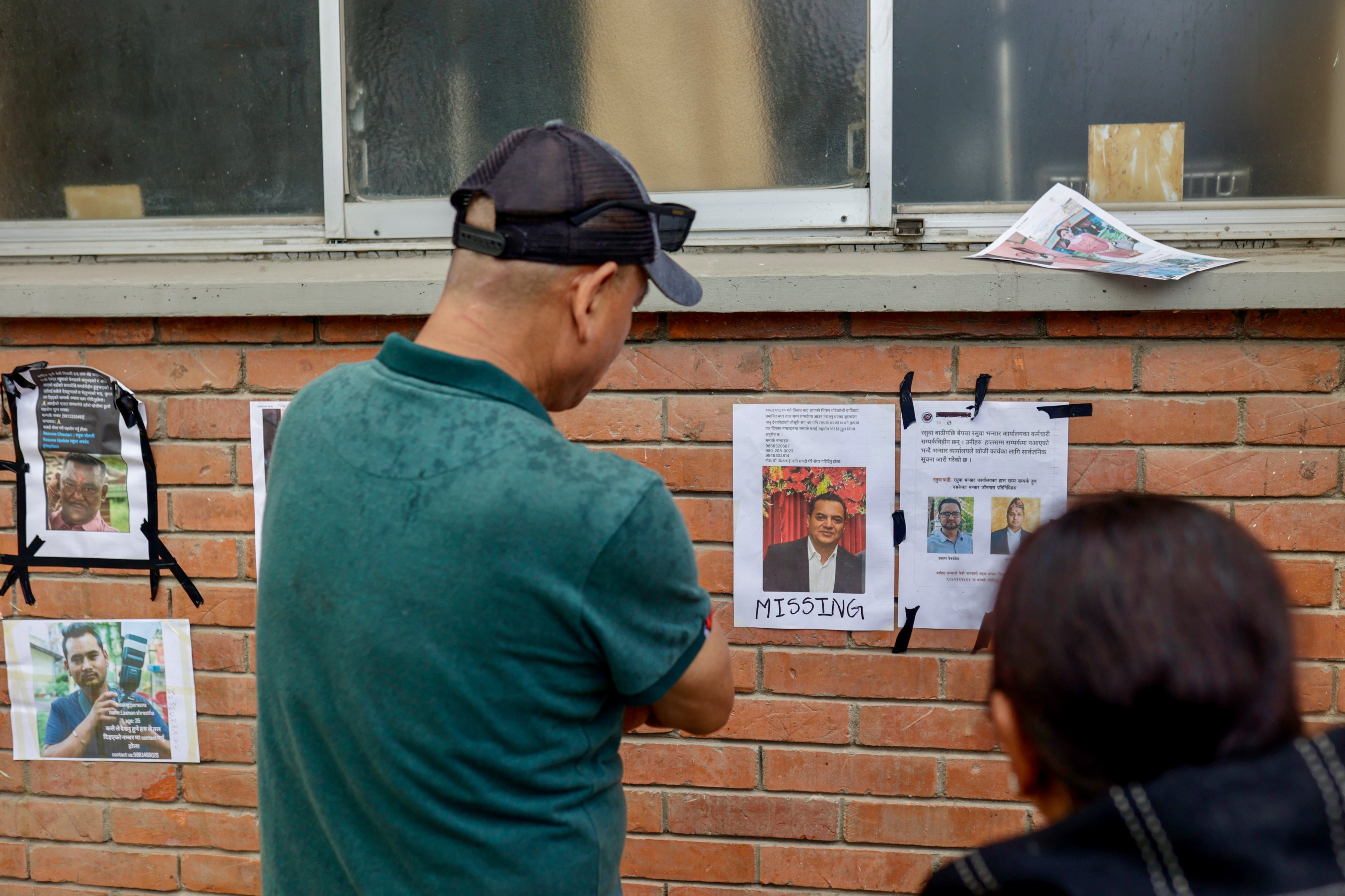People look at photographs of missing people following flash floods at the Tribhuvan University Teaching Hospital in Kathmandu, Nepal, on Friday. Photo: EPA