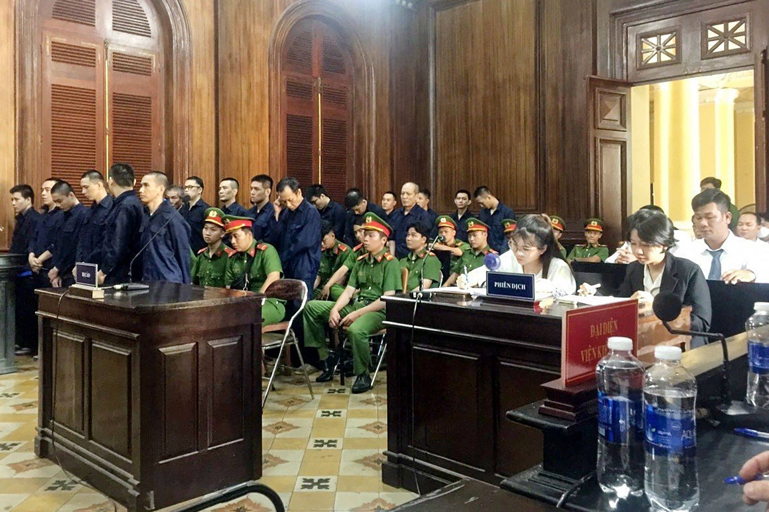 Defendants (in blue) stand during their trial for drug trafficking in Ho Chi Minh on November 12, 2023. Photo:  Vietnam News Agency/AFP