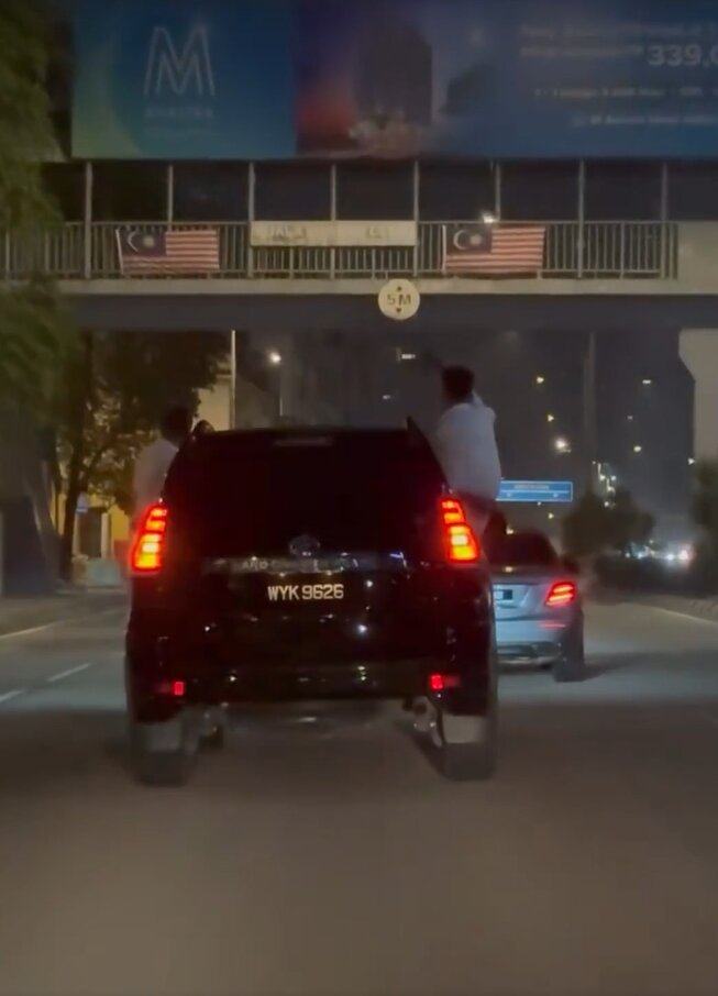 Men hang out a car and sit on the windows in Kuala Lumpur early Friday morning. Photo: Reddit/whusler