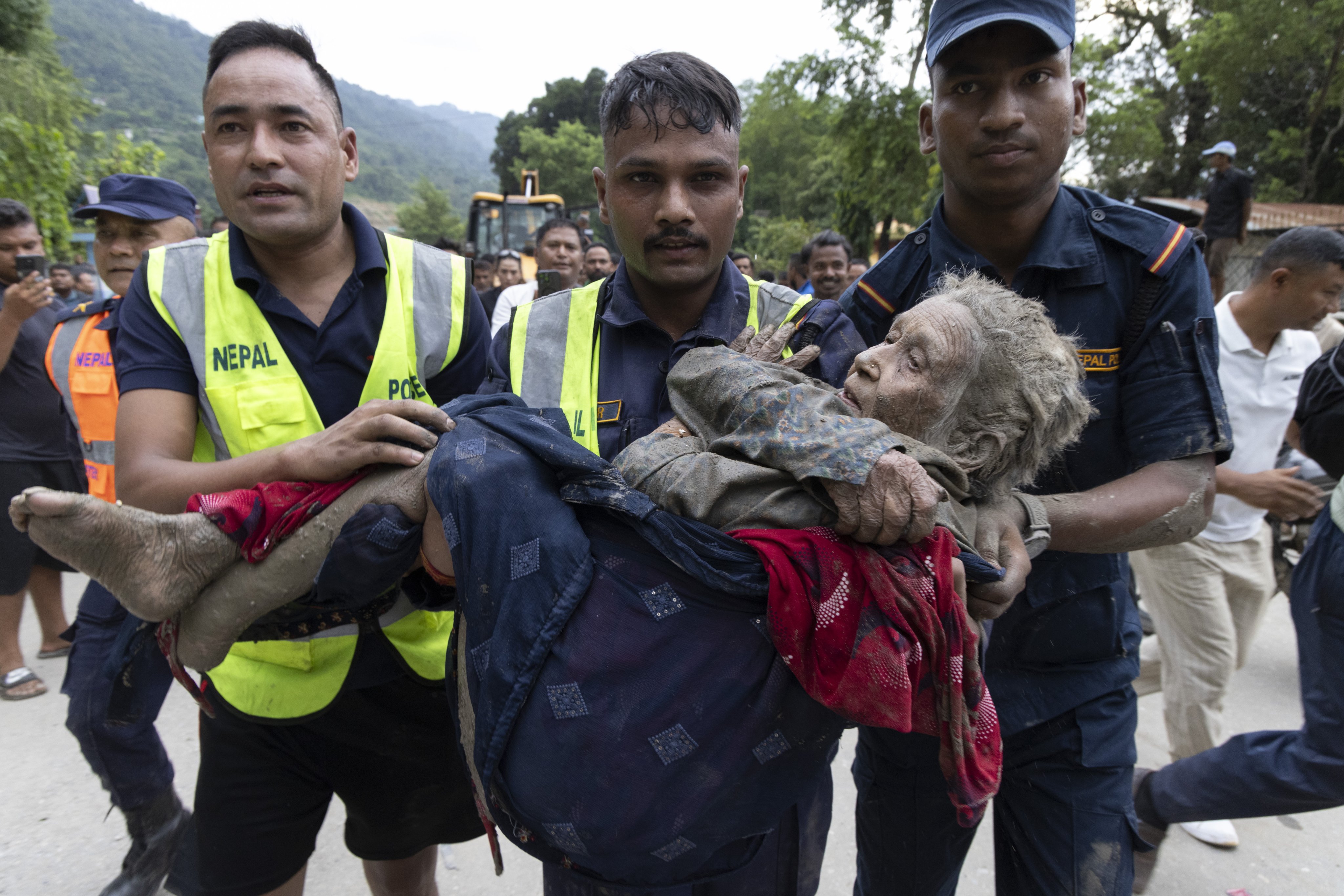 Rescuers transport an elderly woman rescued from a Devighat old age home following a flash flood in Trishuli Bazar, Nuwakot district, Nepal. Photo: EPA