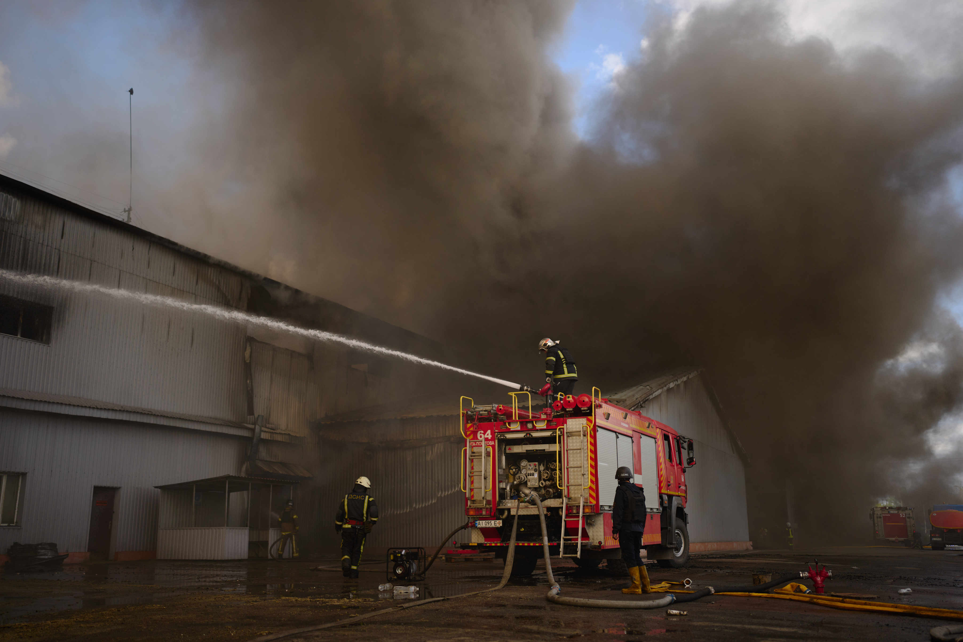 Firefighters try to extinguish a fire at a destroyed warehouse after Russian drone attacks on the outskirts of Kyiv, Ukraine on Friday. Photo: AP