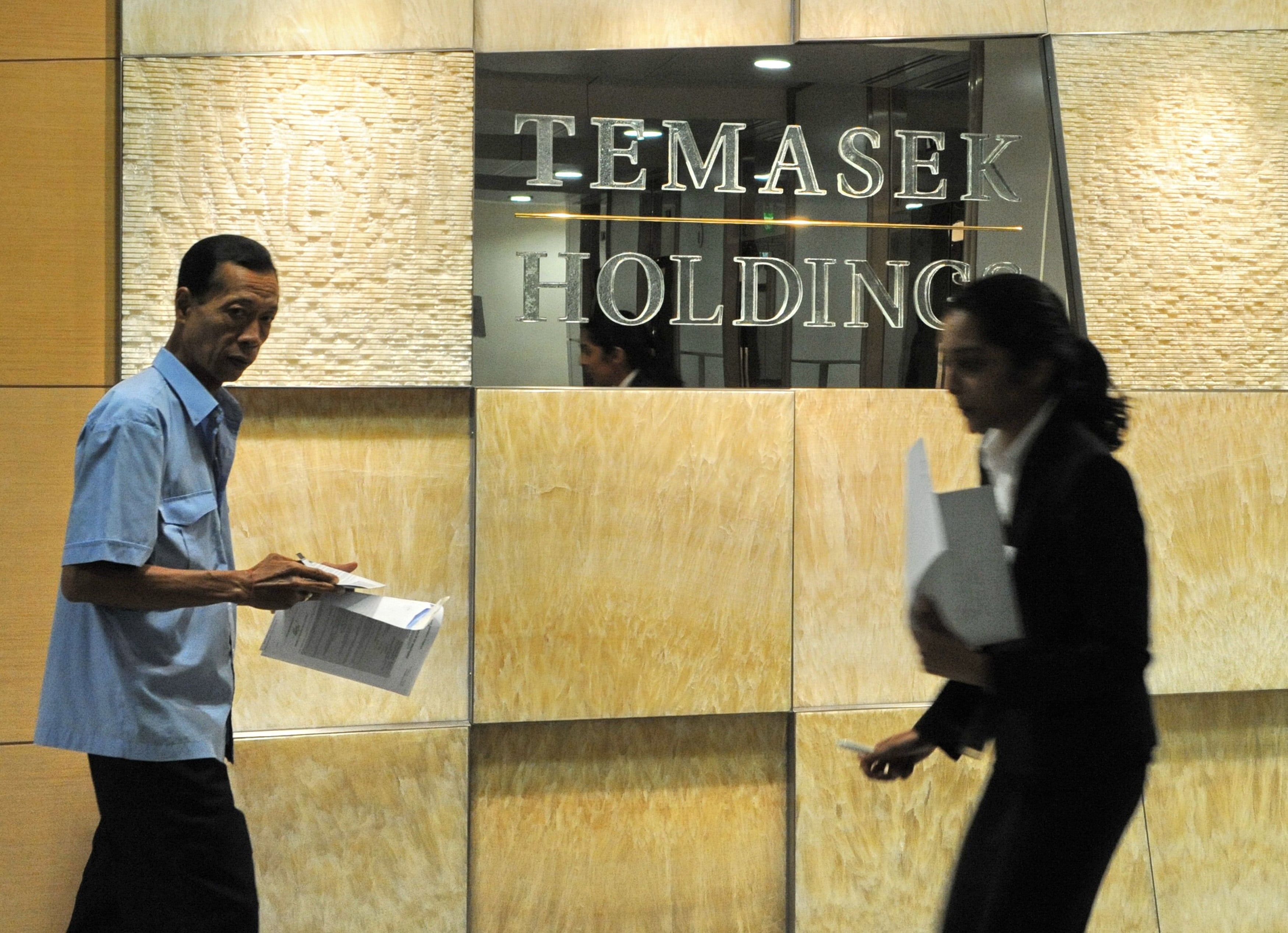 Office workers walk past the Temasek Holdings in Singapore. Photo: AFP