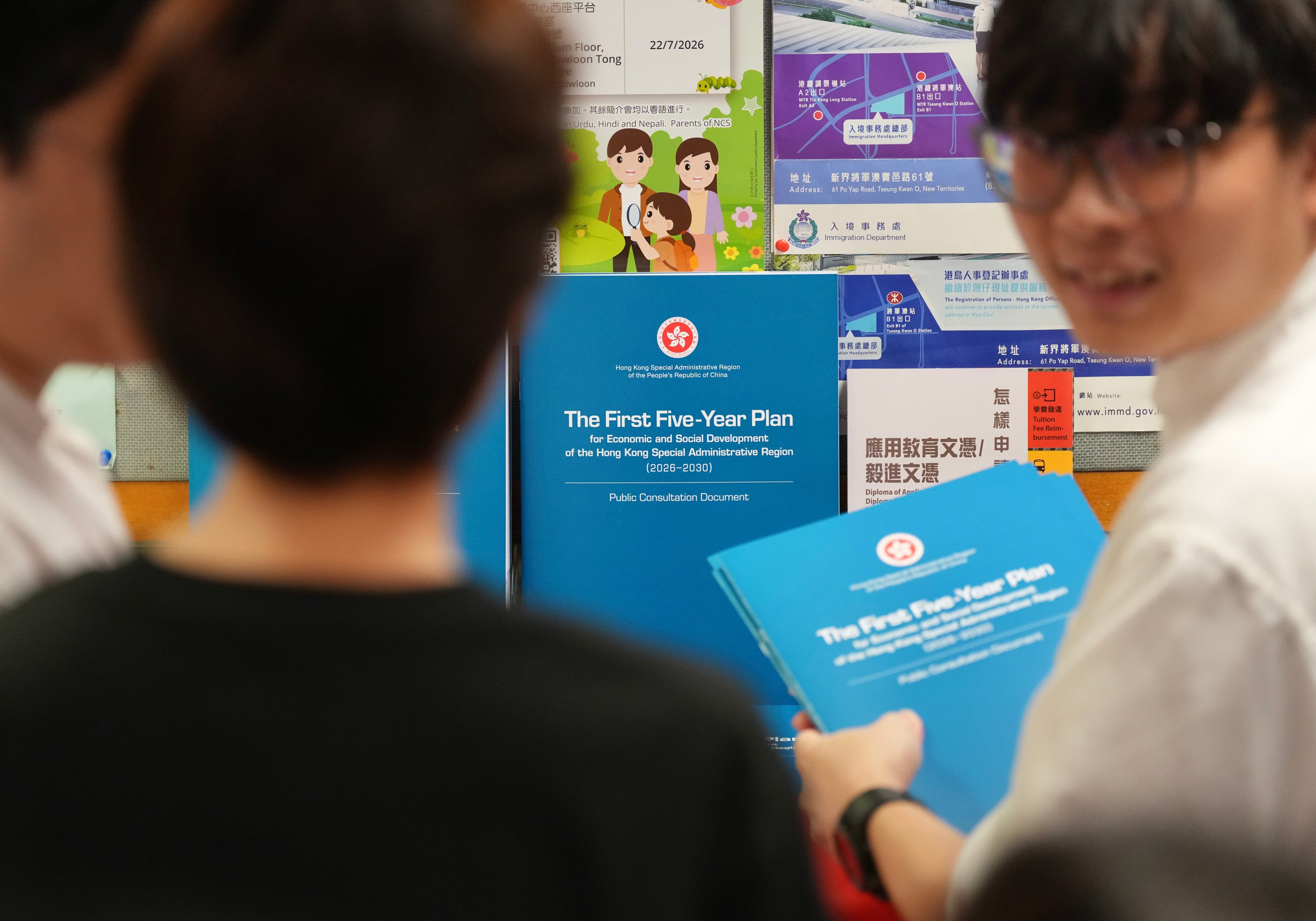 People pick up copies of the consultation document for Hong Kong’s first five-year blueprint. Photo: Karma Lo