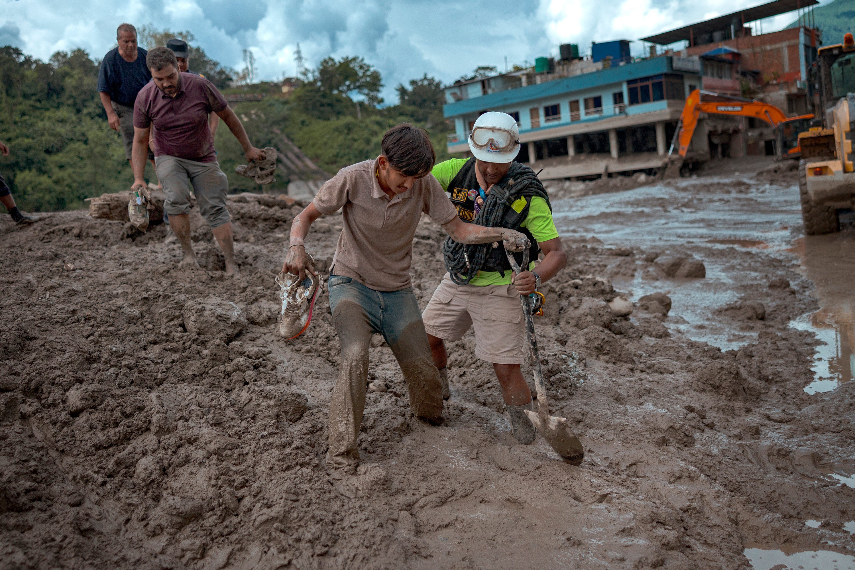 A rescuer helps a resident through heavy mud following flash floods on Thursday in Trishuli, Nepal. Photo: Getty Images/TNS