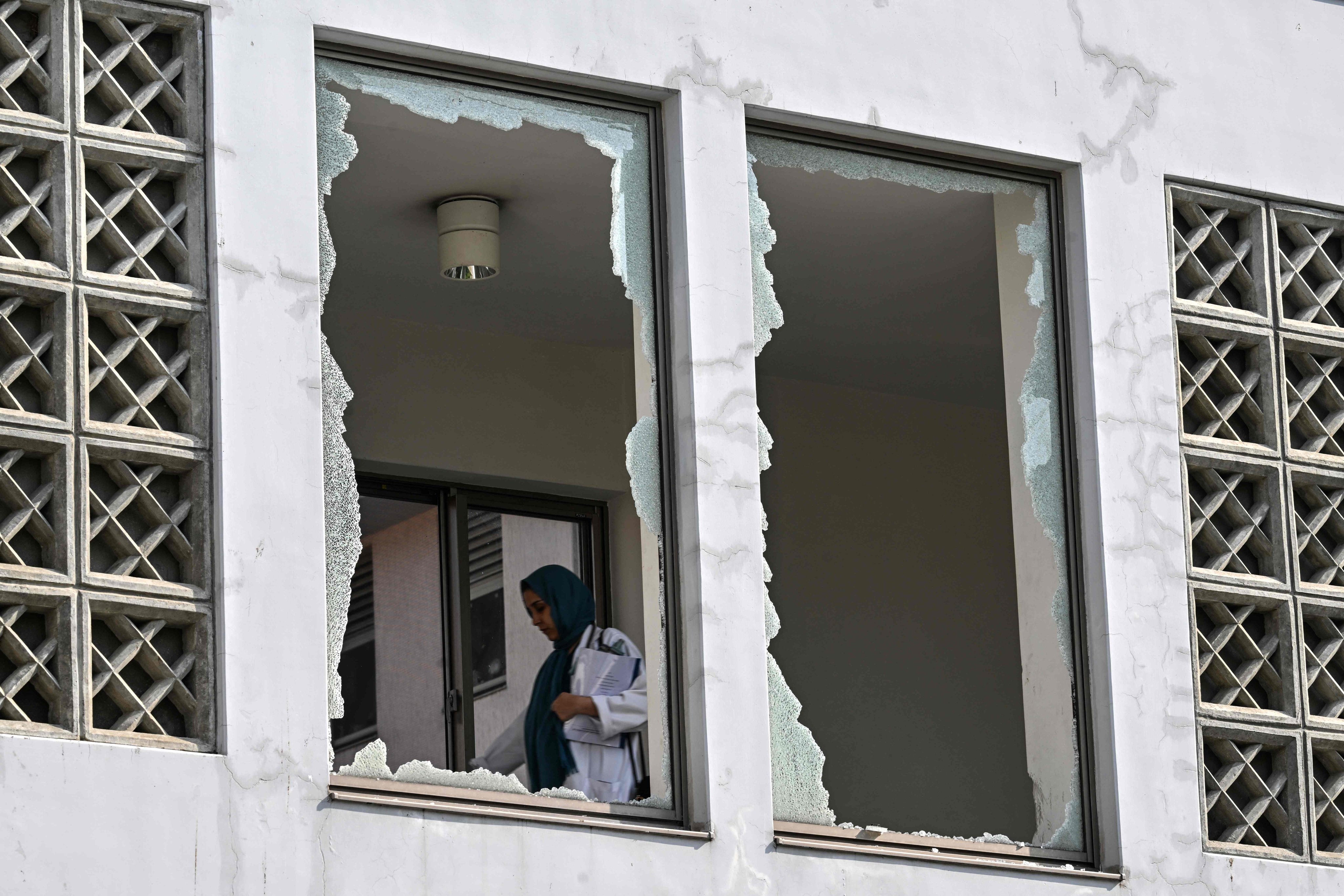 A medical staff member walks past a damaged corridor of the Pakistan Institute of Medical Sciences’ Mother and Child Health ward on Thursday. Photo: AFP