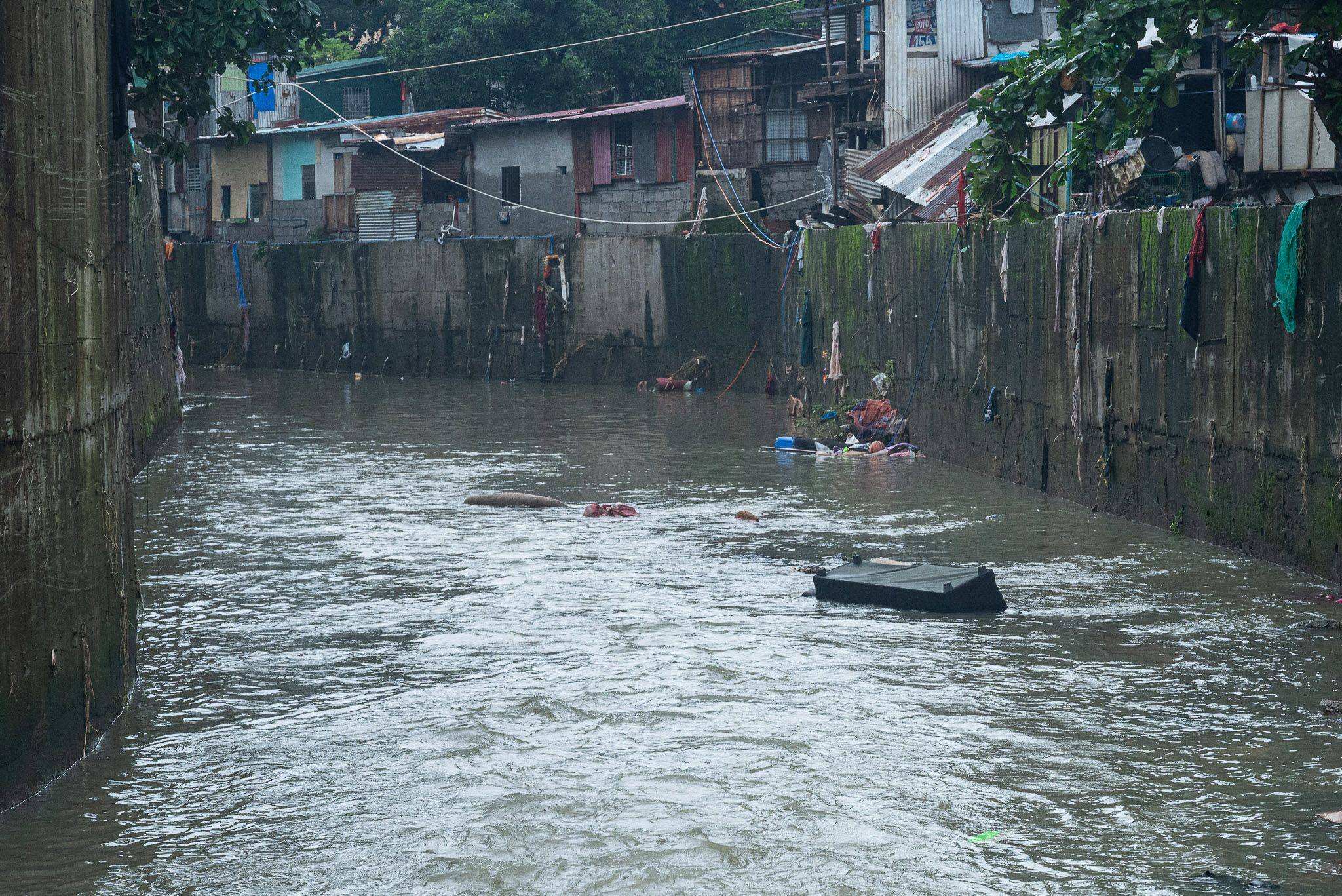 People’s belongings float on a flooded street in Quezon City, the Philippines, on Sunday after monsoon rains caused the La Mesa Dam and the Tullahan river to overflow, flooding nearby low lying areas. Photo: dpa