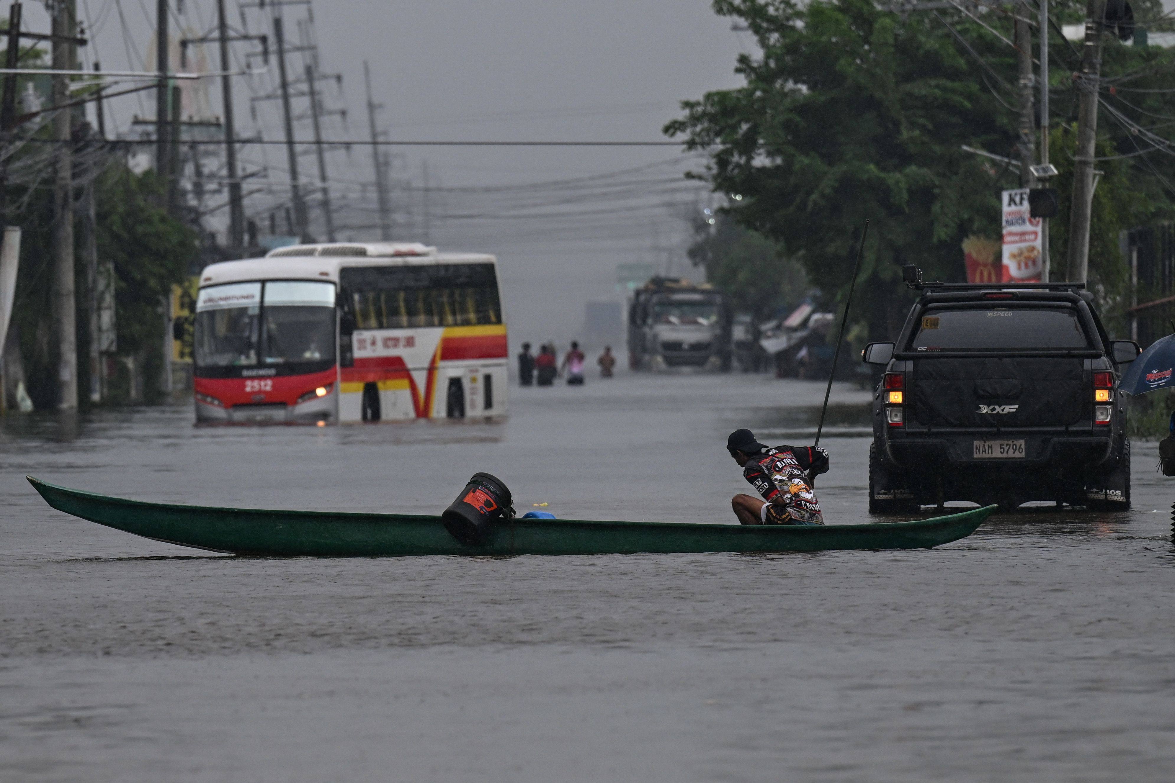 Motorists commute through a flooded street due to rains brought by the southwest monsoon in Pampanga, the Philippines, on Monday. Photo: AFP