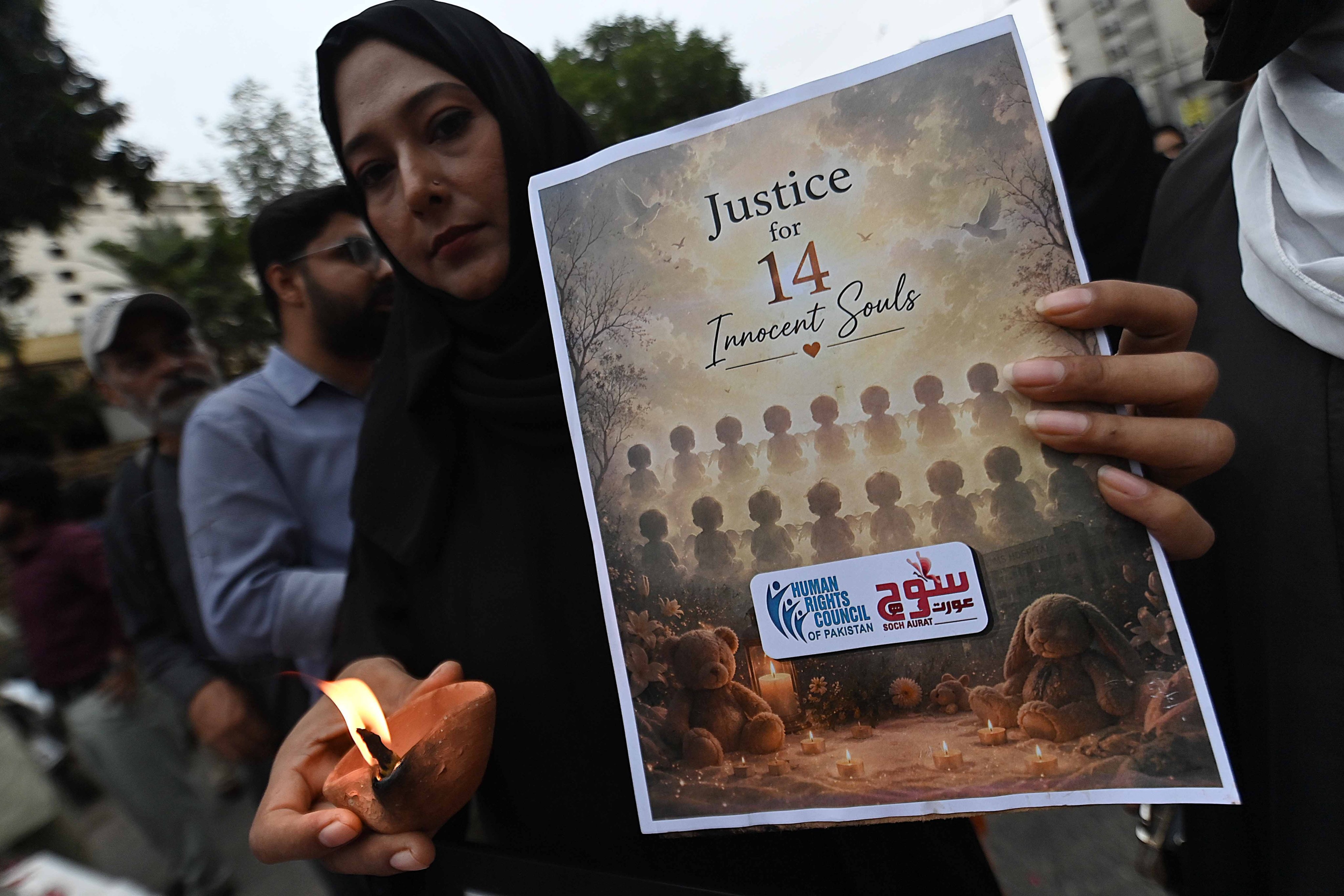 Human rights activists hold a candlelight vigil in Karachi to mourn the deaths of newborns killed in a hospital fire on Friday. Photo: EPA