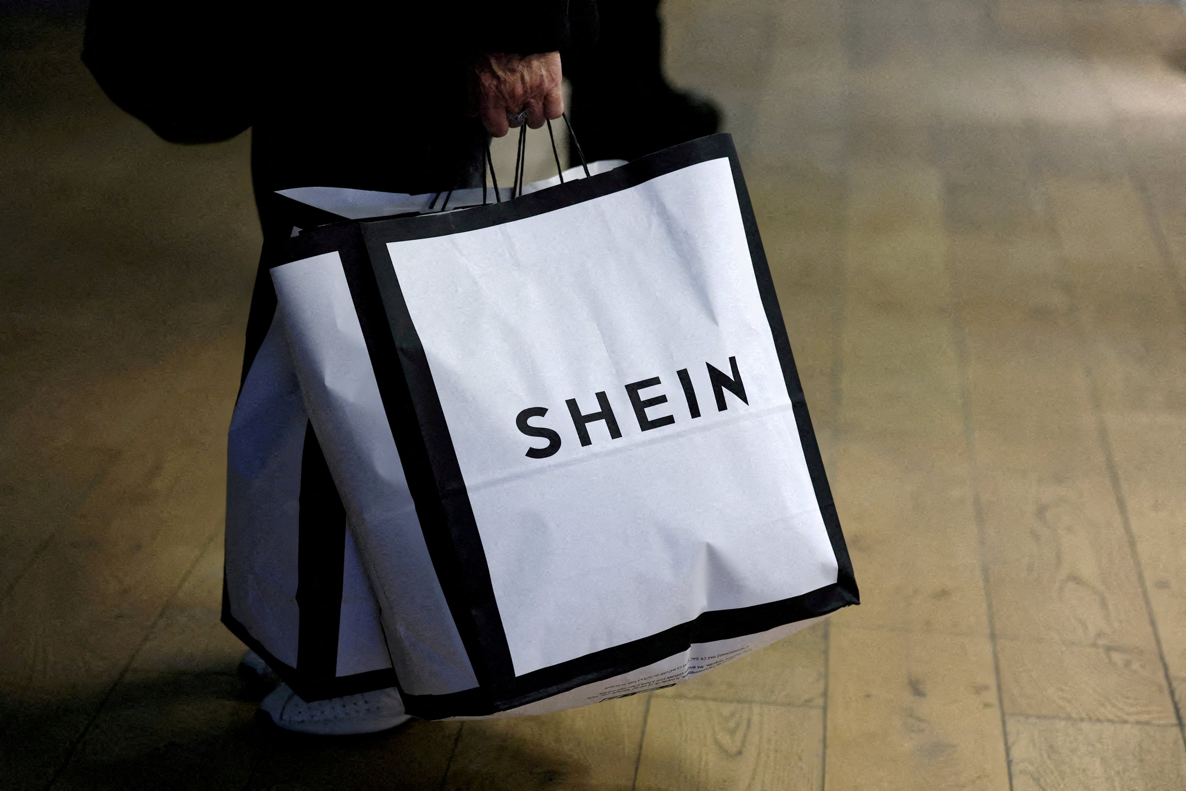 A customer holds shopping bags with the Shein logo. Photo: Reuters