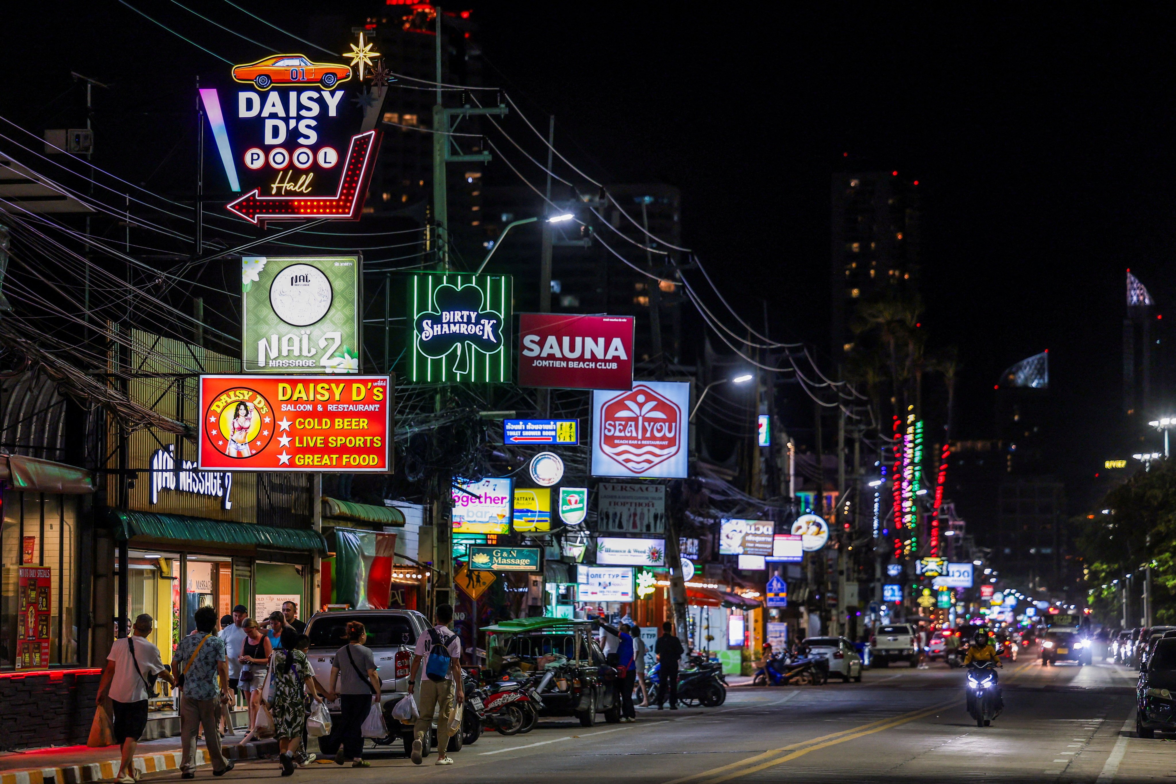 People walk along a street lined with bars and entertainment venues at Jomtien Beach, in Pattaya City, Thailand, in June. Photo: Reuters