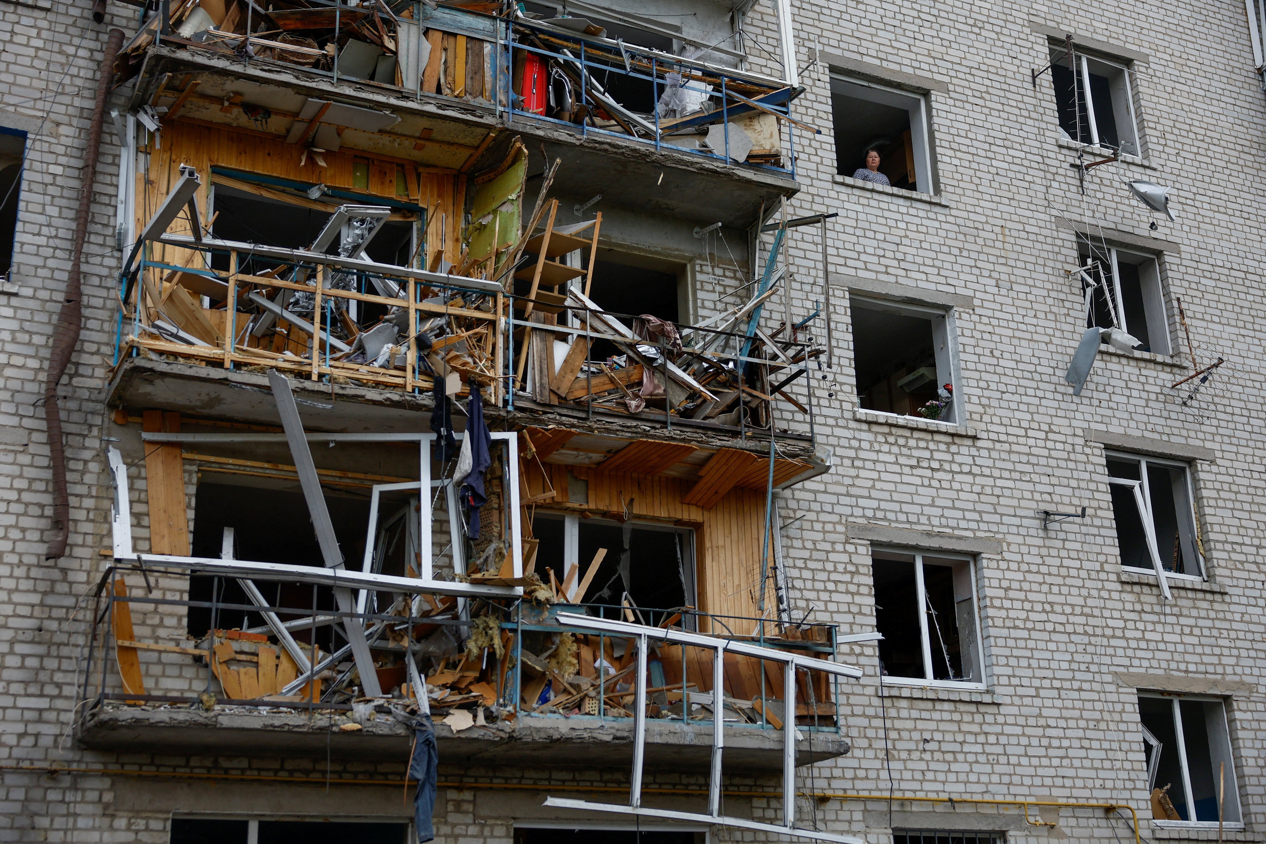 A woman looks from the window of her flat after a Russian missile strike in the town of Boryspil, Kyiv region. Photo: Reuters
