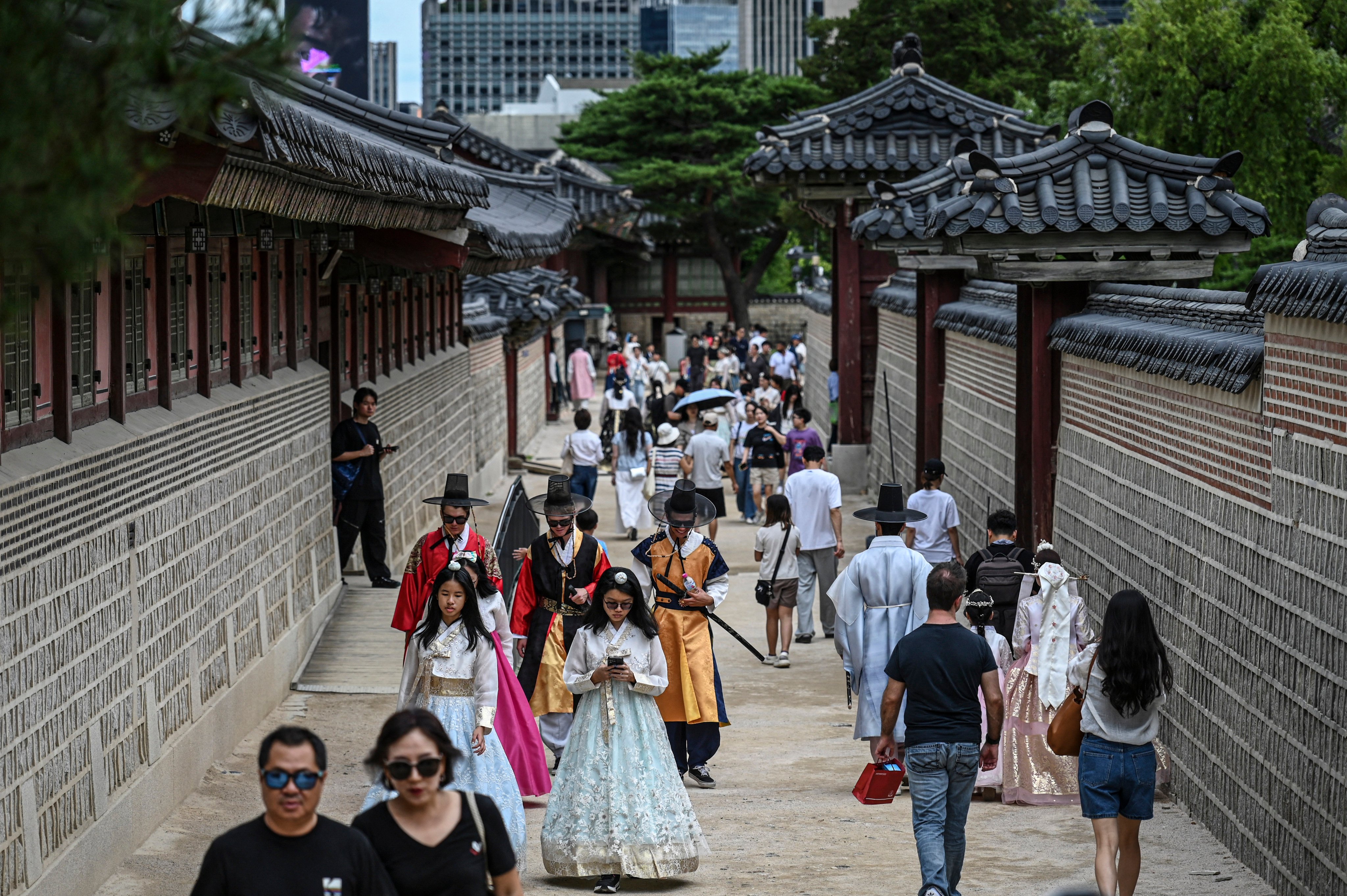 Visitors walks through the Gyeongbokgung Palace in Seoul on June 21, 2026. (Photo by JADE GAO / AFP)