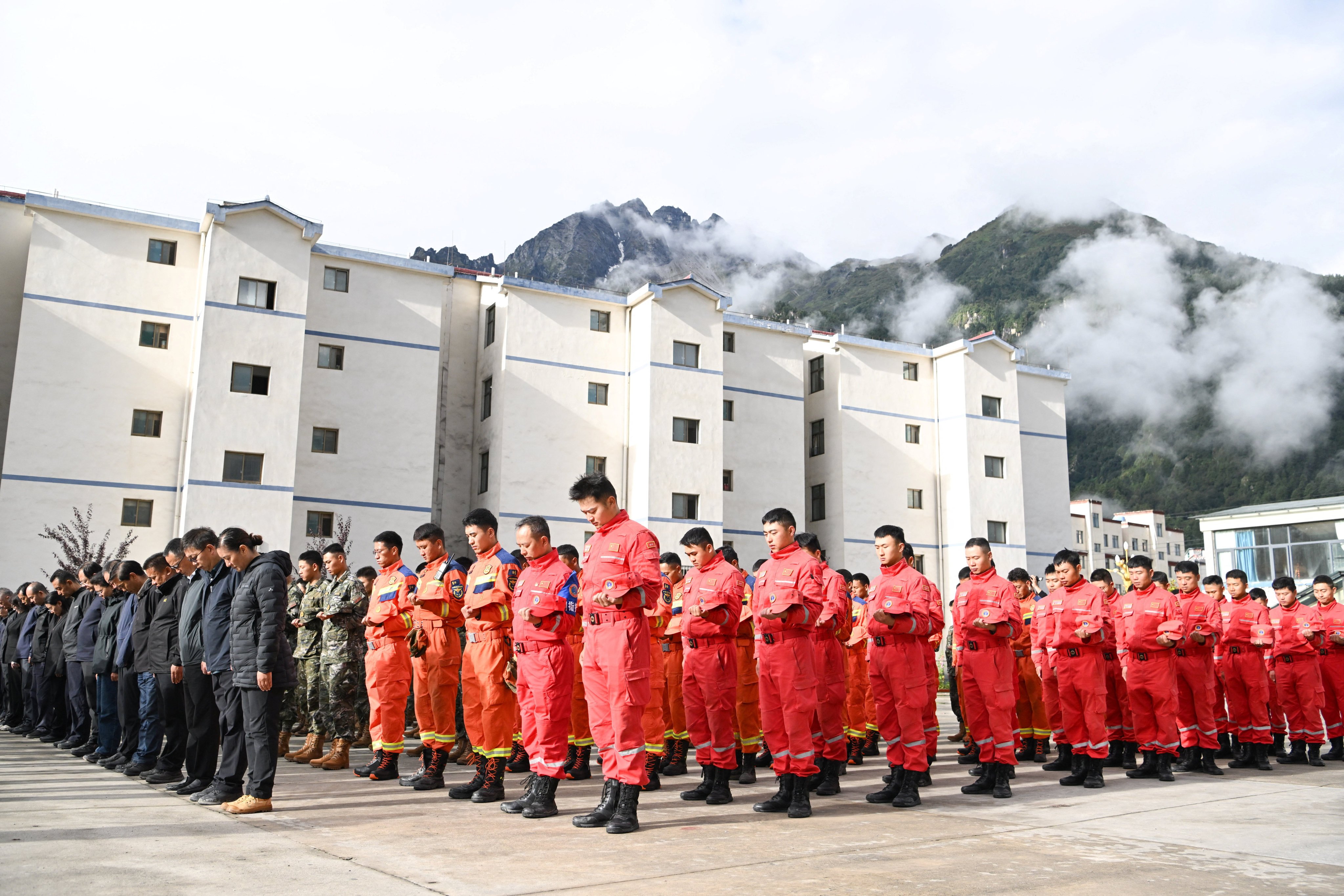 Rescue workers, local officials and residents stand in silence during a memorial service to mourn the victims of the August 26 mudslide, in Gyirong county, Shigatse, Tibet Autonomous Region, China September 1, 2026. cnsphoto via REUTERS   ATTENTION EDITORS - THIS IMAGE WAS PROVIDED BY A THIRD PARTY. CHINA OUT.