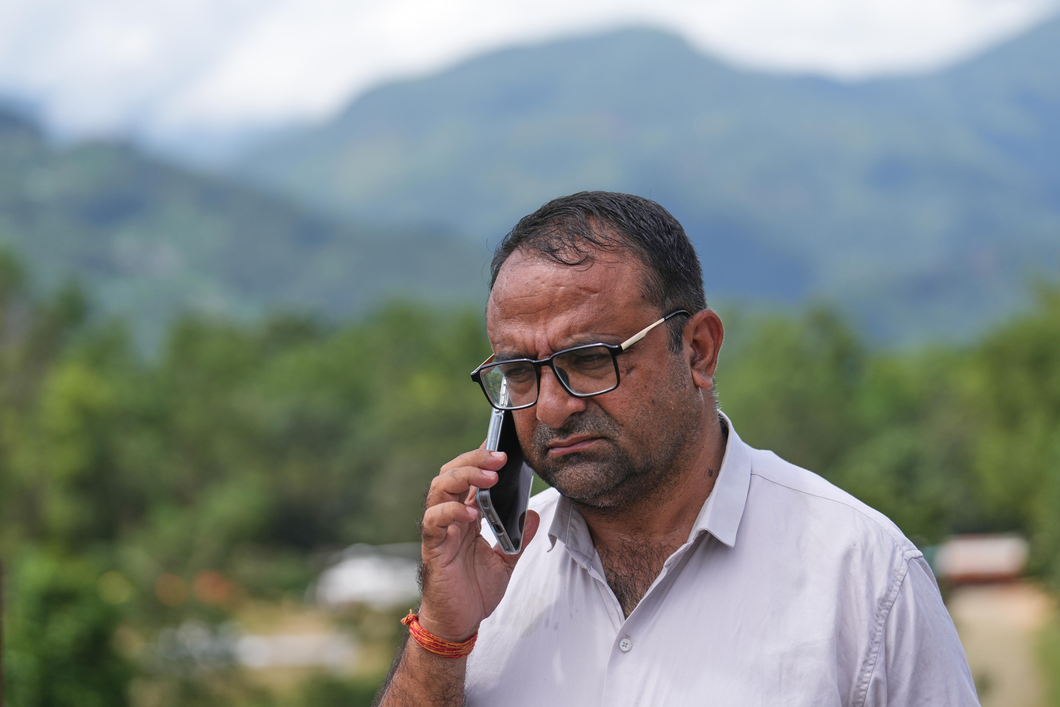Tribhuvan Trishuli Secondary School principal Rajendra Dawadi talks on his mobile phone in Trishuli Valley in Nepal’s Nuwakot district on Monday. Photo: AP