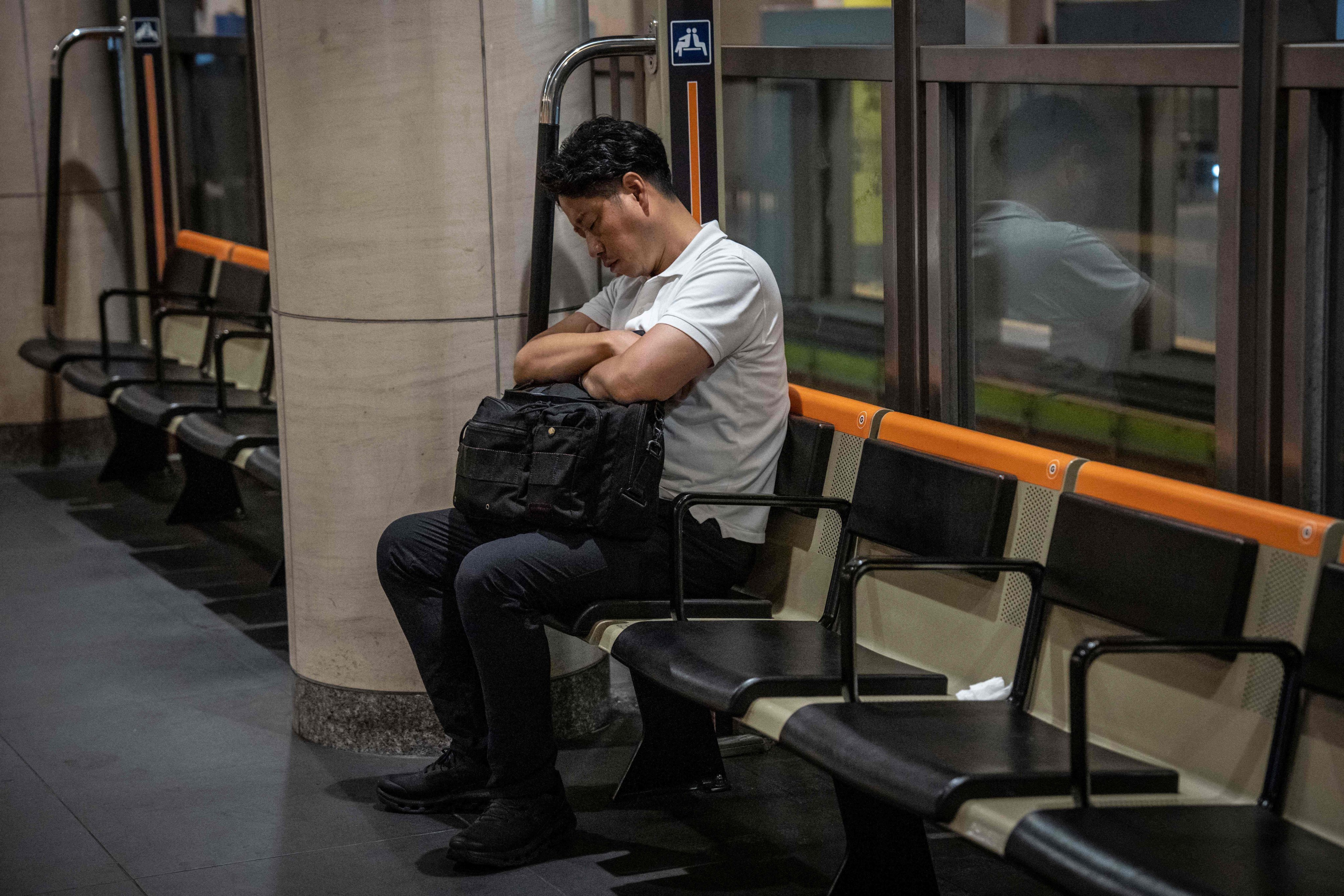 A man sleeps on a bench at a railway station in Tokyo on Tuesday. Photo: AFP