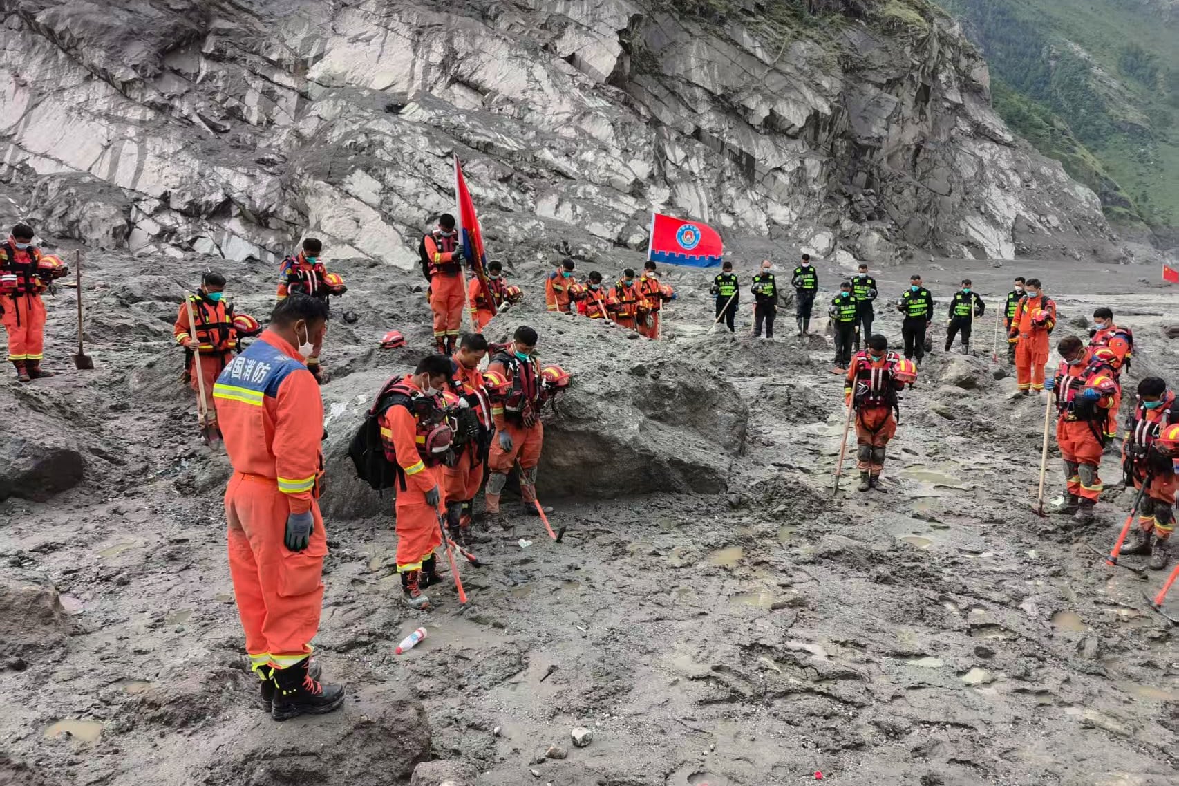 Rescuers observe a moment of silence for the victims of the mudslide in Gyirong county, Tibet. Photo: AP