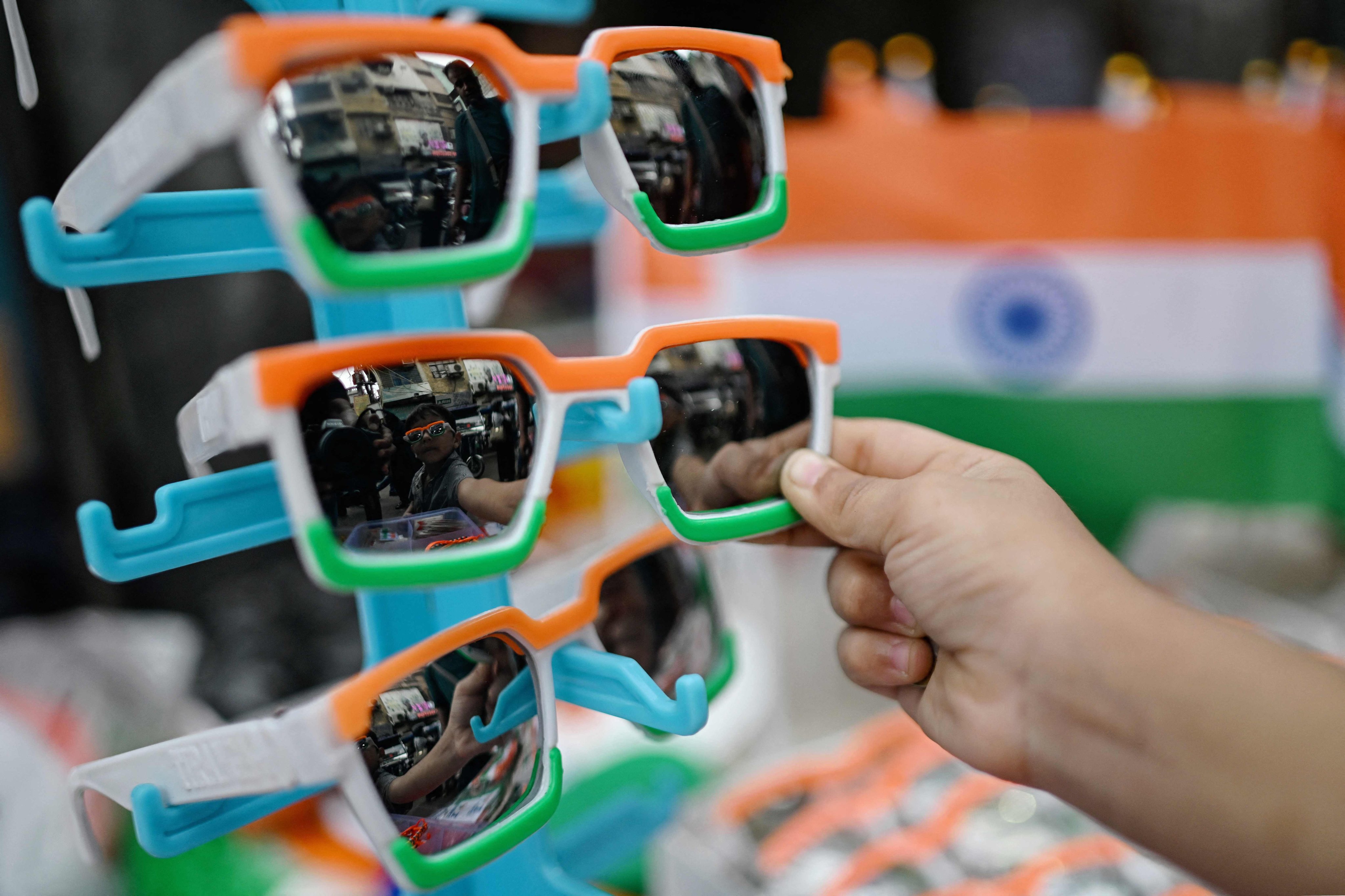 A child looks at tricoloured sunglasses at a market in the old quarters of Delhi on August 11. Photo: AFP