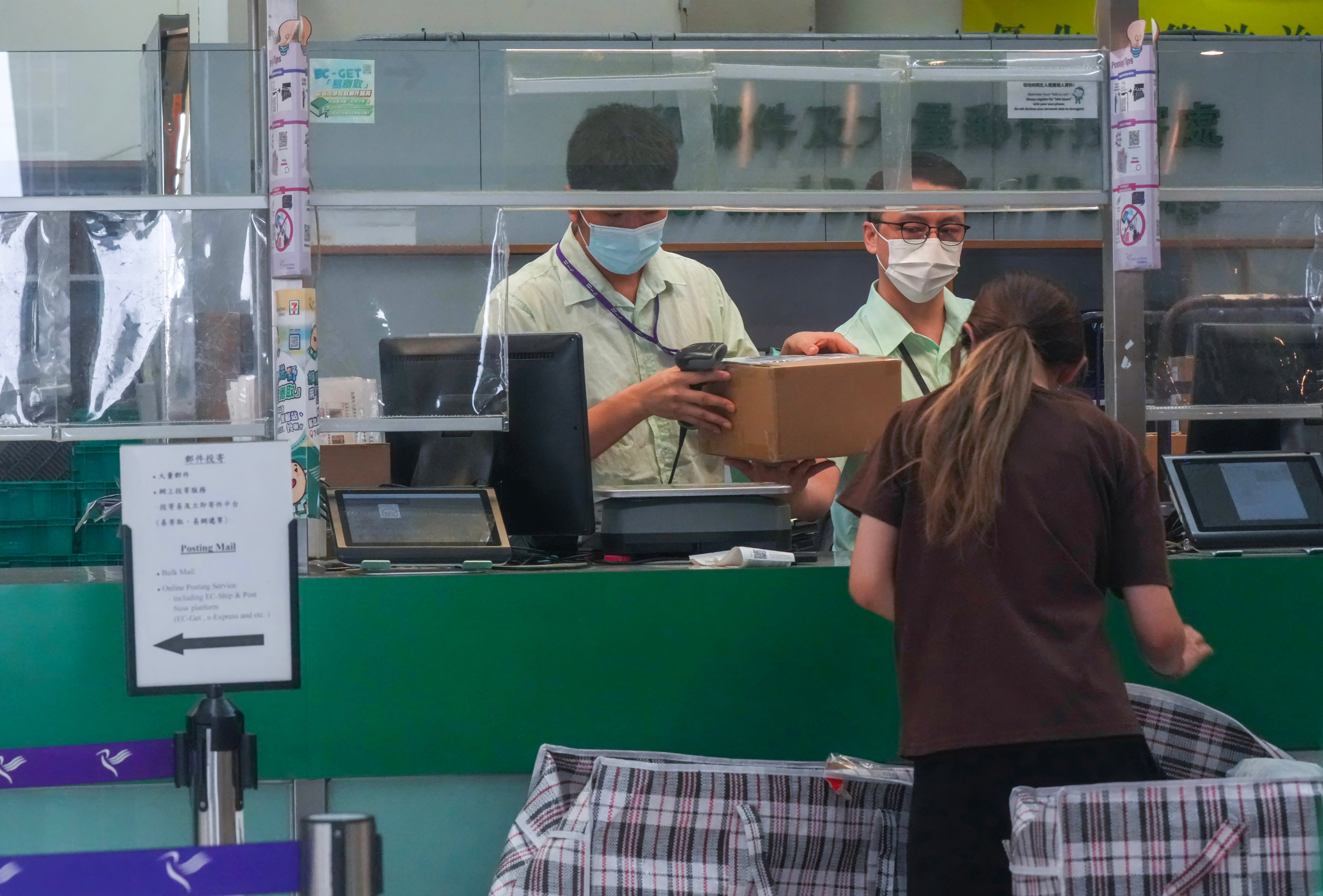 Staff members help a customer at the General Post Office in Central on August 18. Some 200 employees still on probation will be affected by the decision to end offers of permanent civil service positions at Hongkong Post. Photo: Jelly Tse