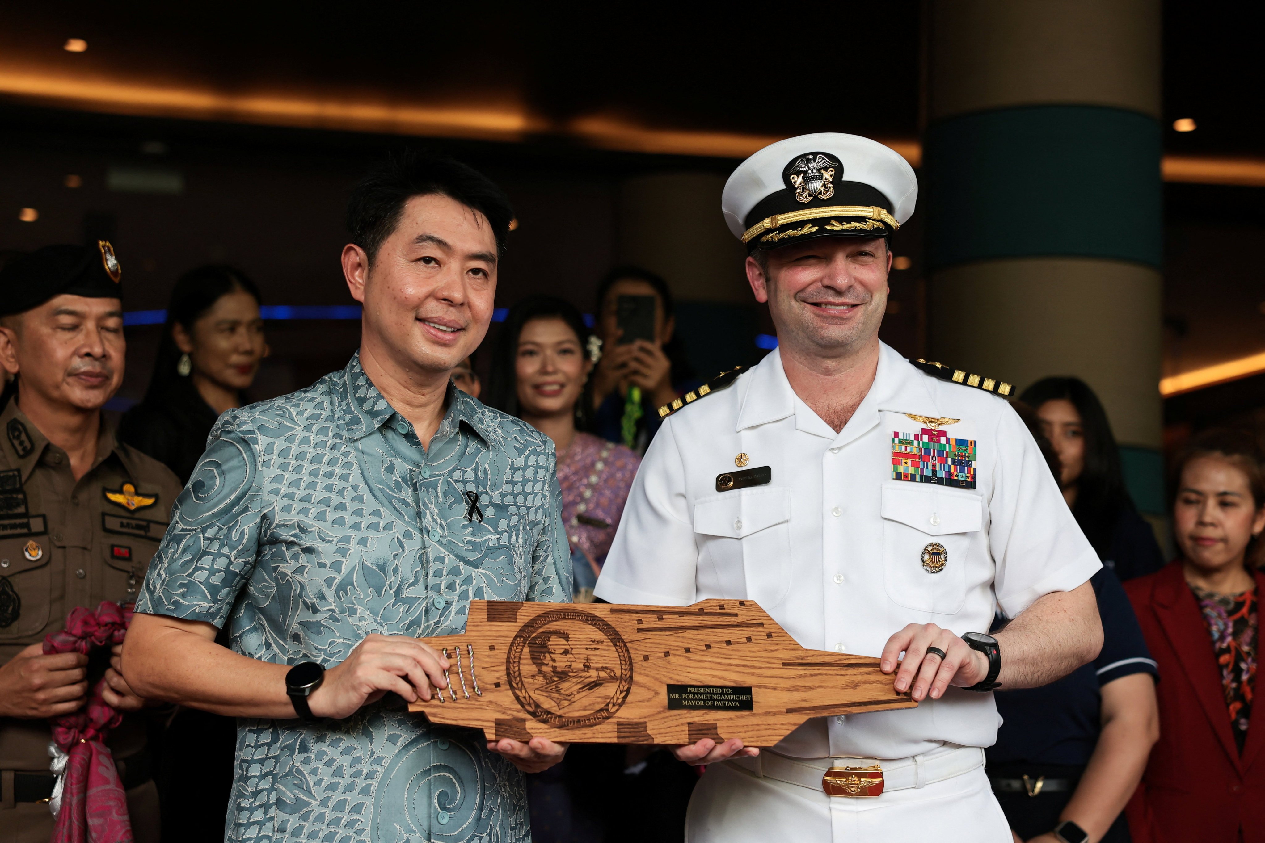 USS Abraham Lincoln’s commanding officer Dan Keeler gives a souvenir to Pattaya Mayor Poramase Ngampiches at Hard Rock Hotel Pattaya on Wednesday. Photo: Reuters