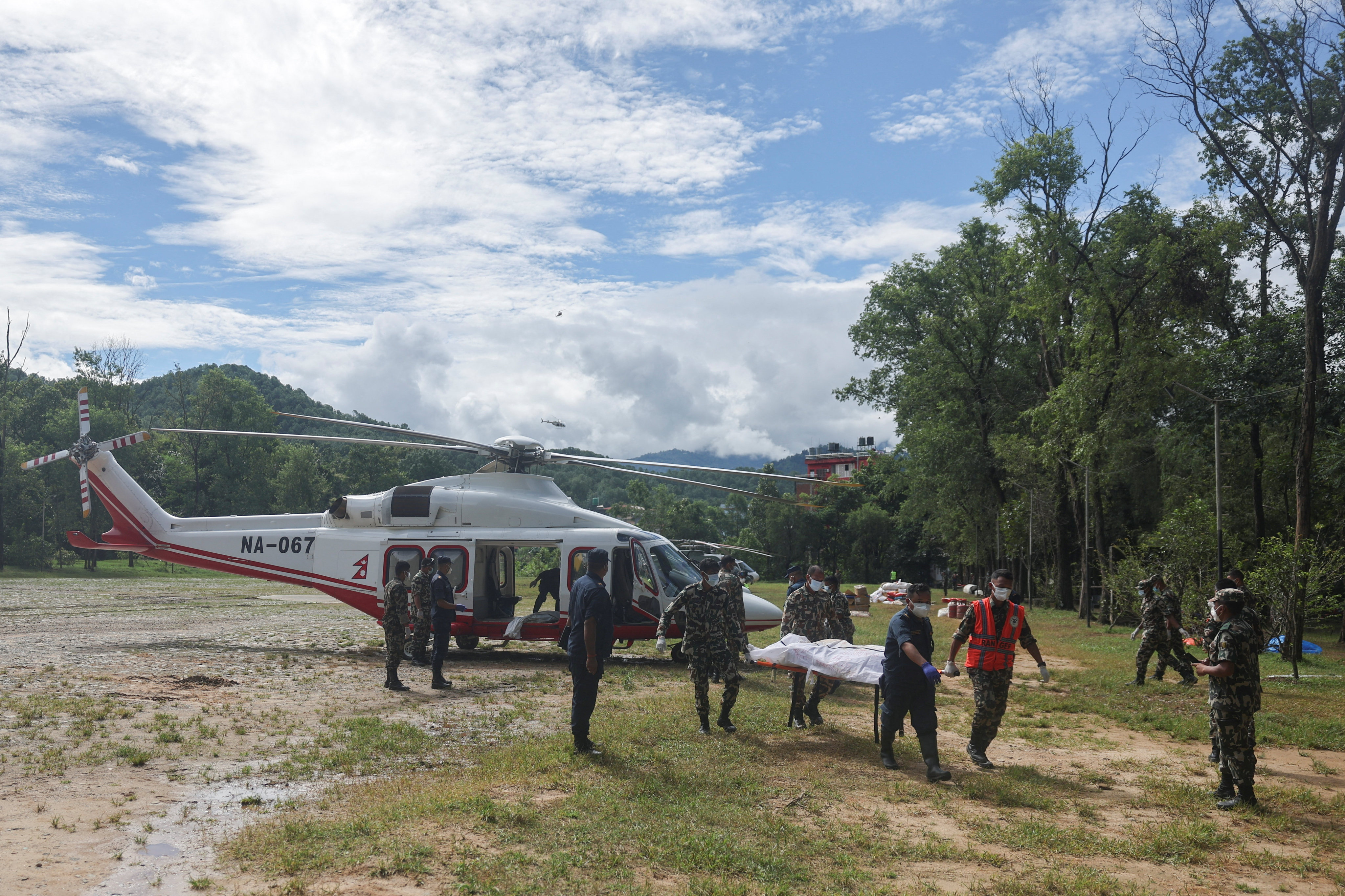 Army rangers and a policeman carry a victim airlifted from an area affected by flash floods in Trishuli, Nepal, on Wednesday. Photo: Reuters