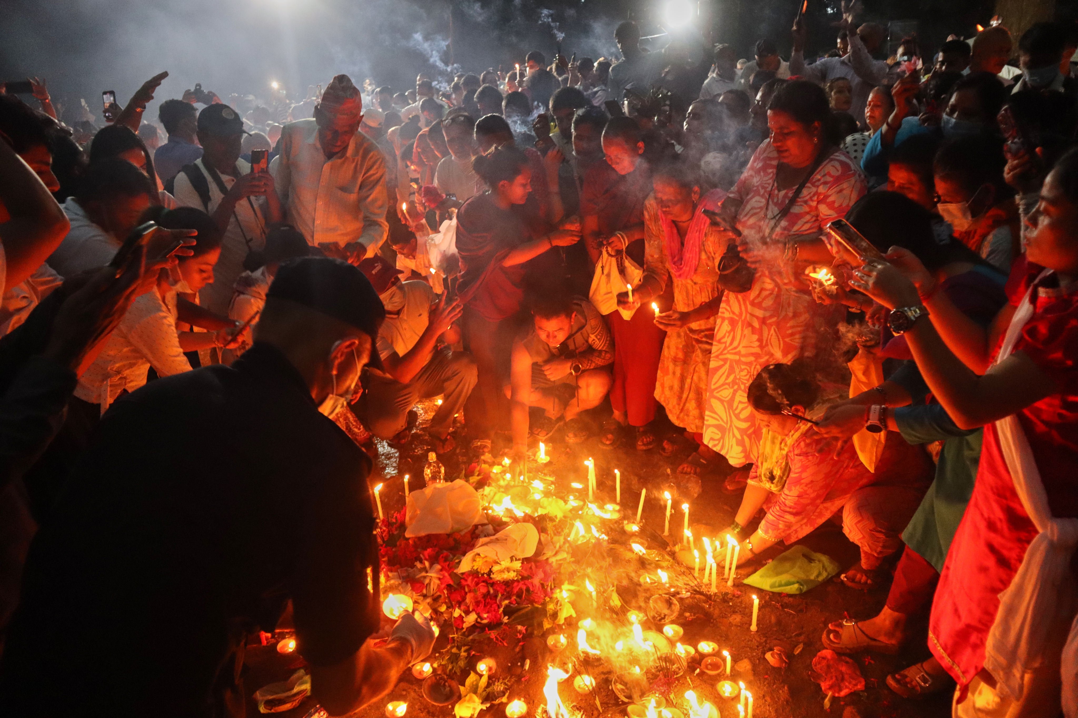 People gather to light candles and pray for the victims of flash floods at the site of a mass burial in Chitwan, Nepal, on Tuesday. Photo: AP