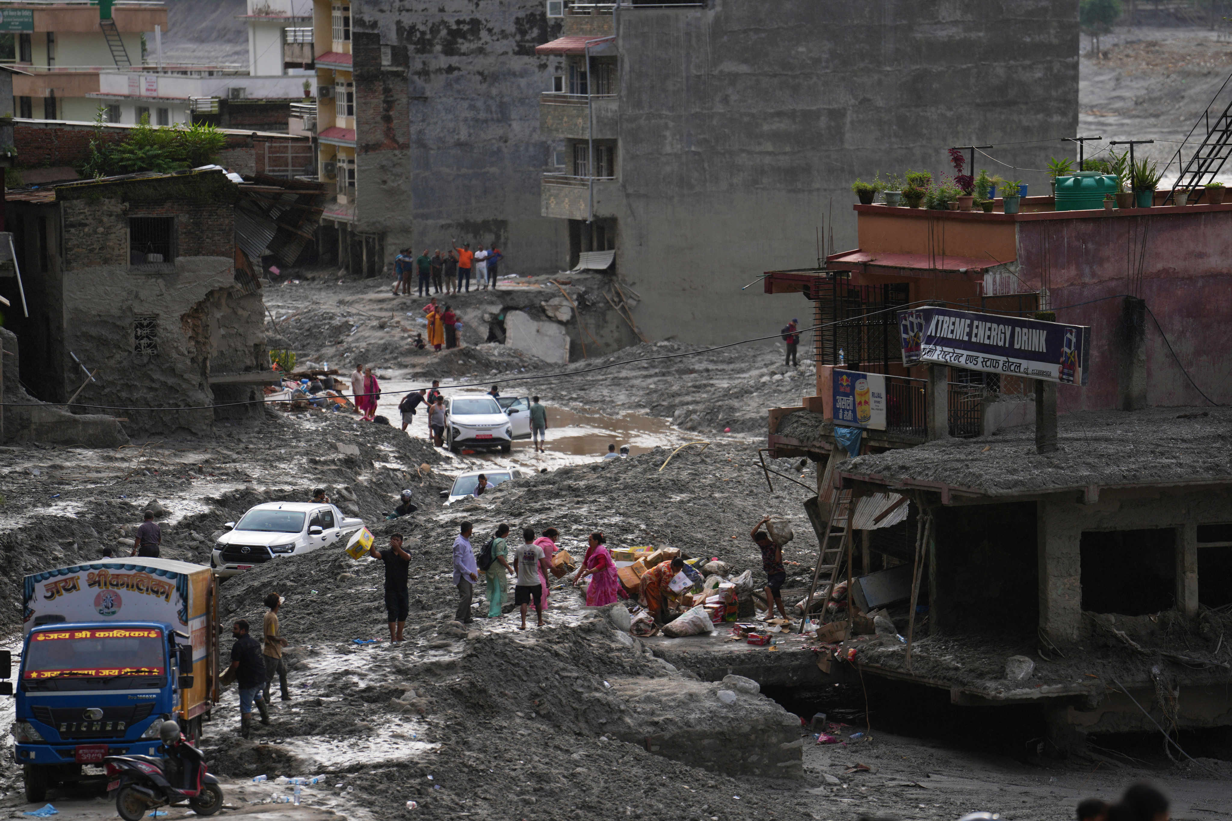 People salvage their belongings from a building damaged by flash flooding in Nuwakot district of Nepal on Tuesday. Photo: AP