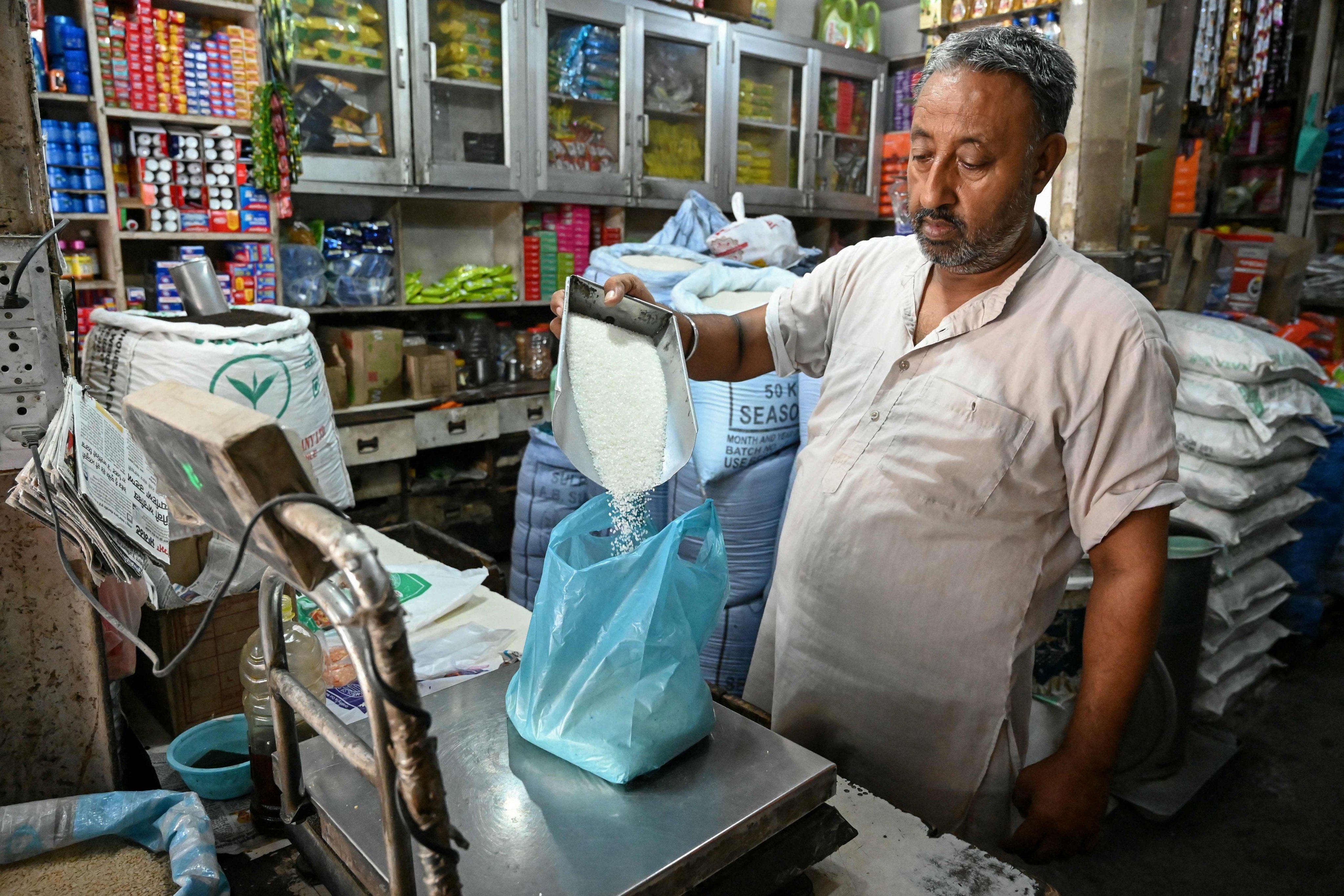 A vendor weighs sugar for a customer at a grocery shop in Amritsar, India, on August 26. Photo: AFP