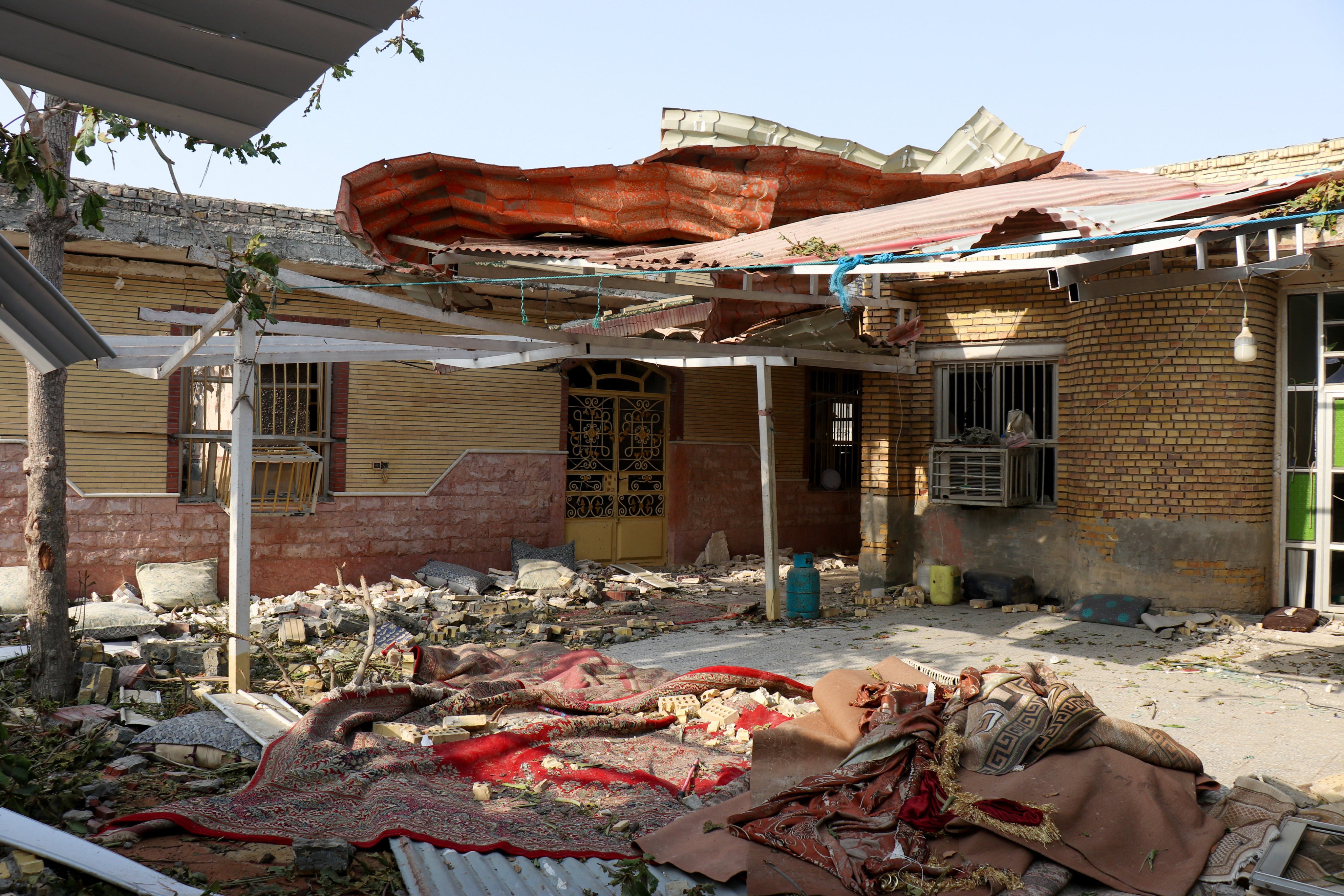 Rubble lies around the damaged house. Photo: West Asia News Agency via Reuters