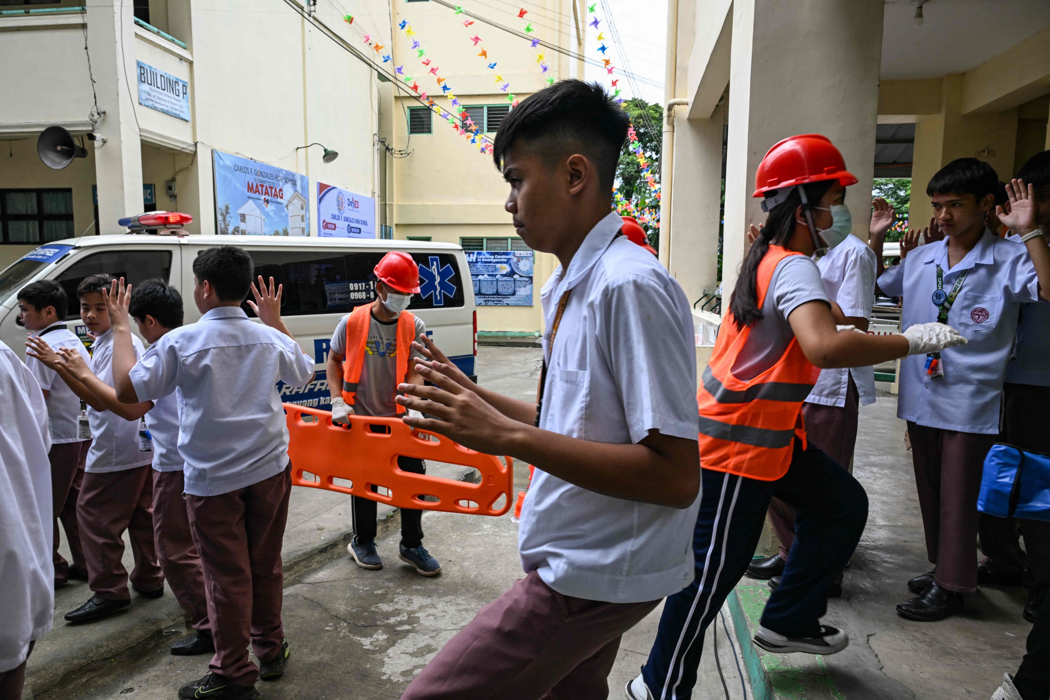 Students raise their hands as they evacuate during nationwide school drills to safeguard students from armed intruders, at a school in Bulacan, the Philippines, on Thursday. Photo: AFP