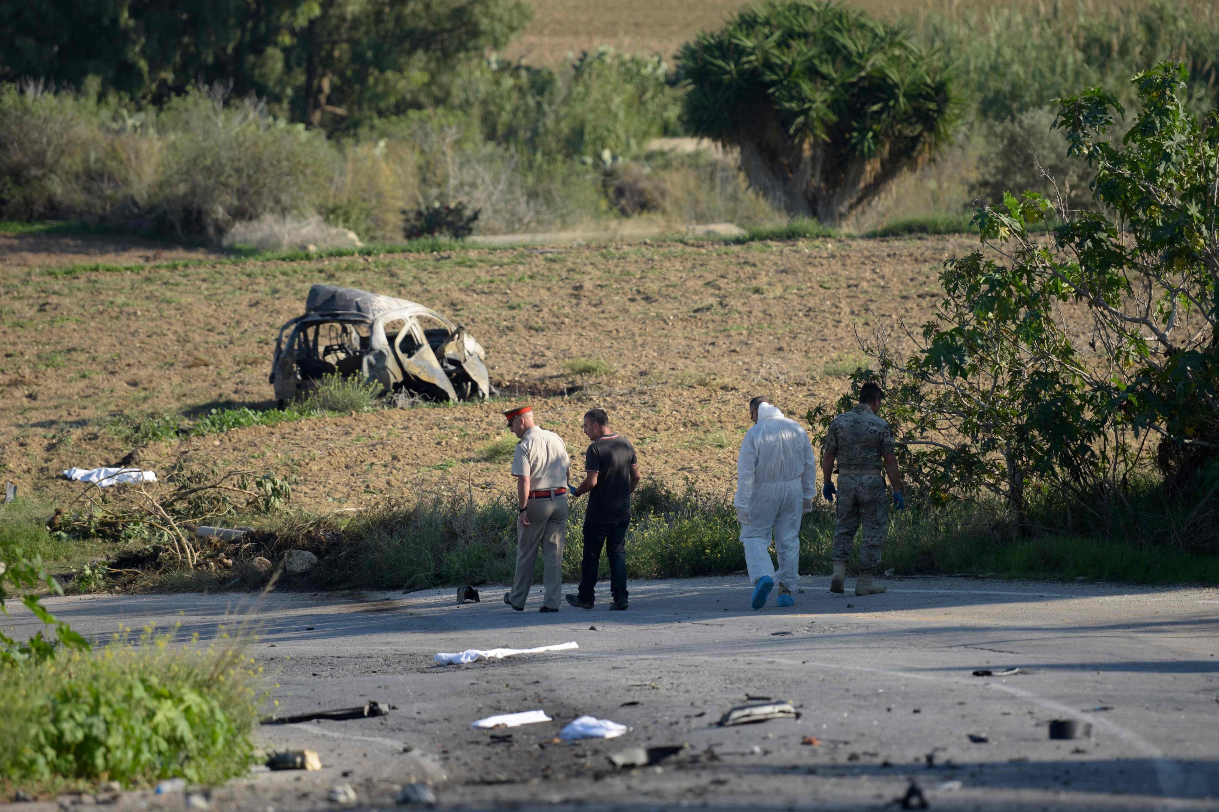 Police and forensic experts inspect the wreckage of the car bomb that killed Daphne Caruana Galizia in 2017. Photo: AFP