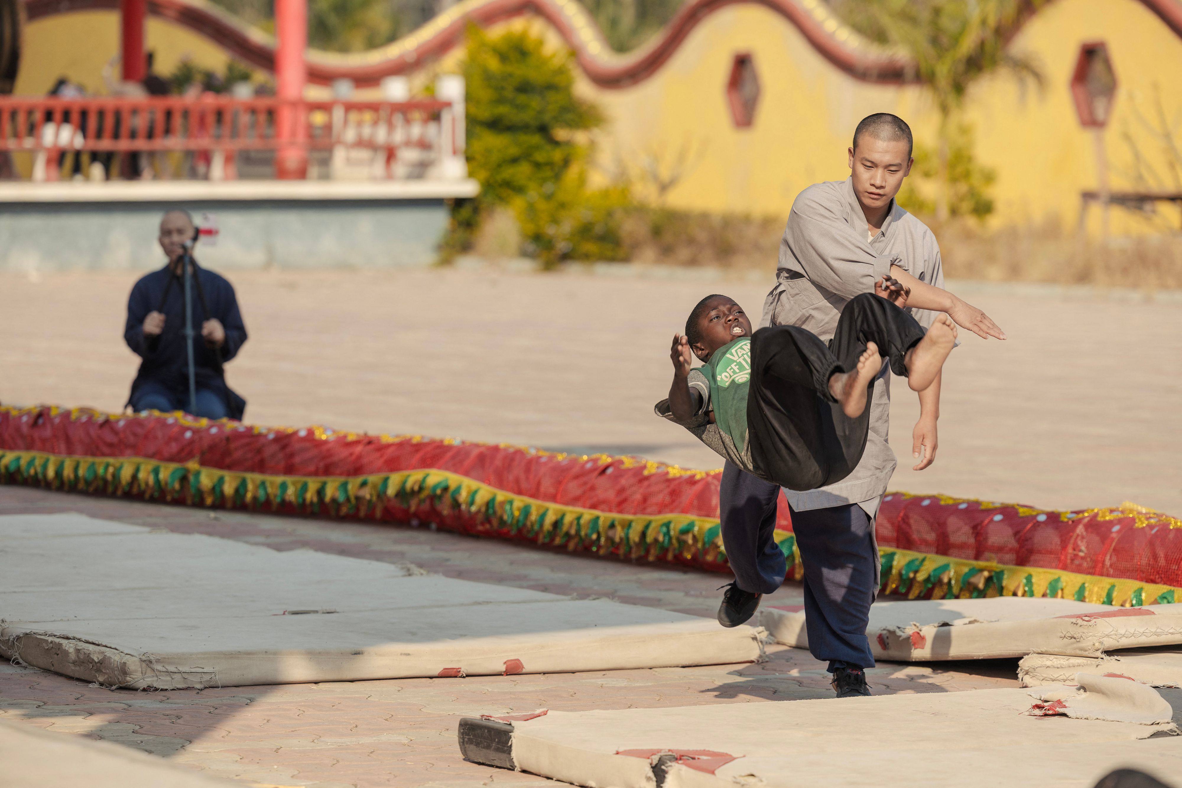 Shaolin monk Yan Chen helps a student do a somersault during a training session at the Shaolin Temple in Ngwerere, outside Lusaka, Zambia, on August 8, 2026. Photo: AFP