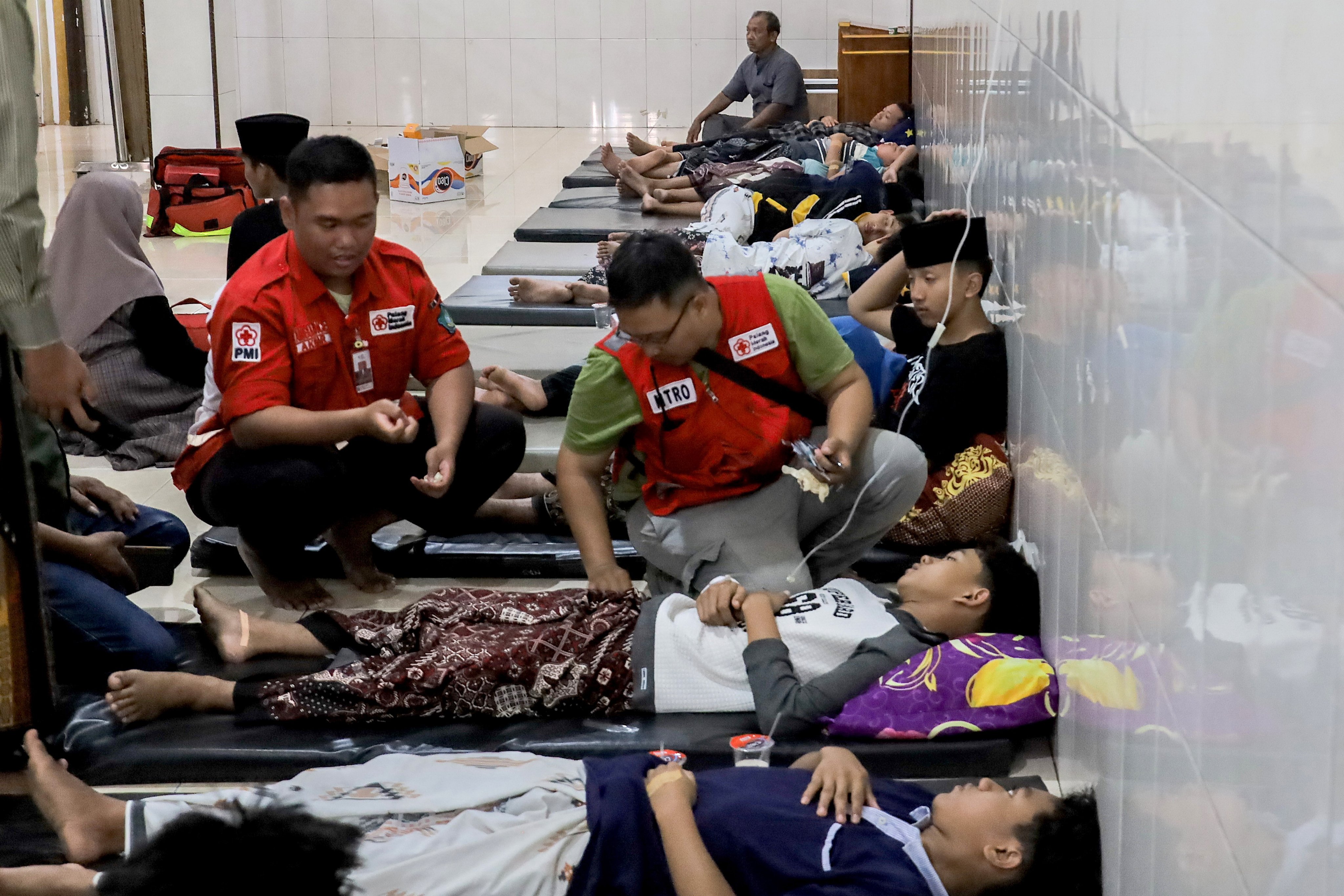Students with food poisoning receive treatment in a mosque in Sidoarjo, East Java, on Wednesday. Hundreds of students had food poisoning symptoms after eating meals under the free nutritious meals programme. Photo: EPA