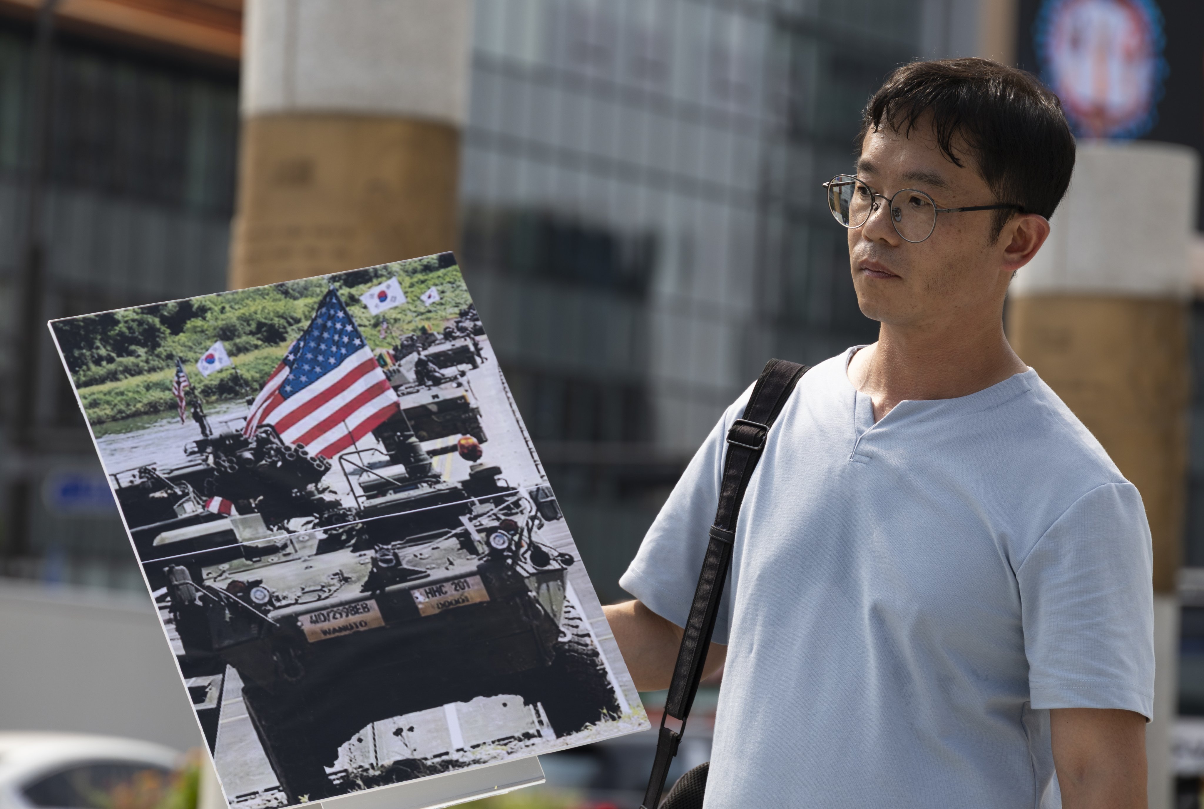 A member of the Korean Peace Solidarity for Sovereignty and Reunification holds a picture during a rally against US-South Korean military exercises outside the US Embassy in Seoul on August 4. Photo: EPA