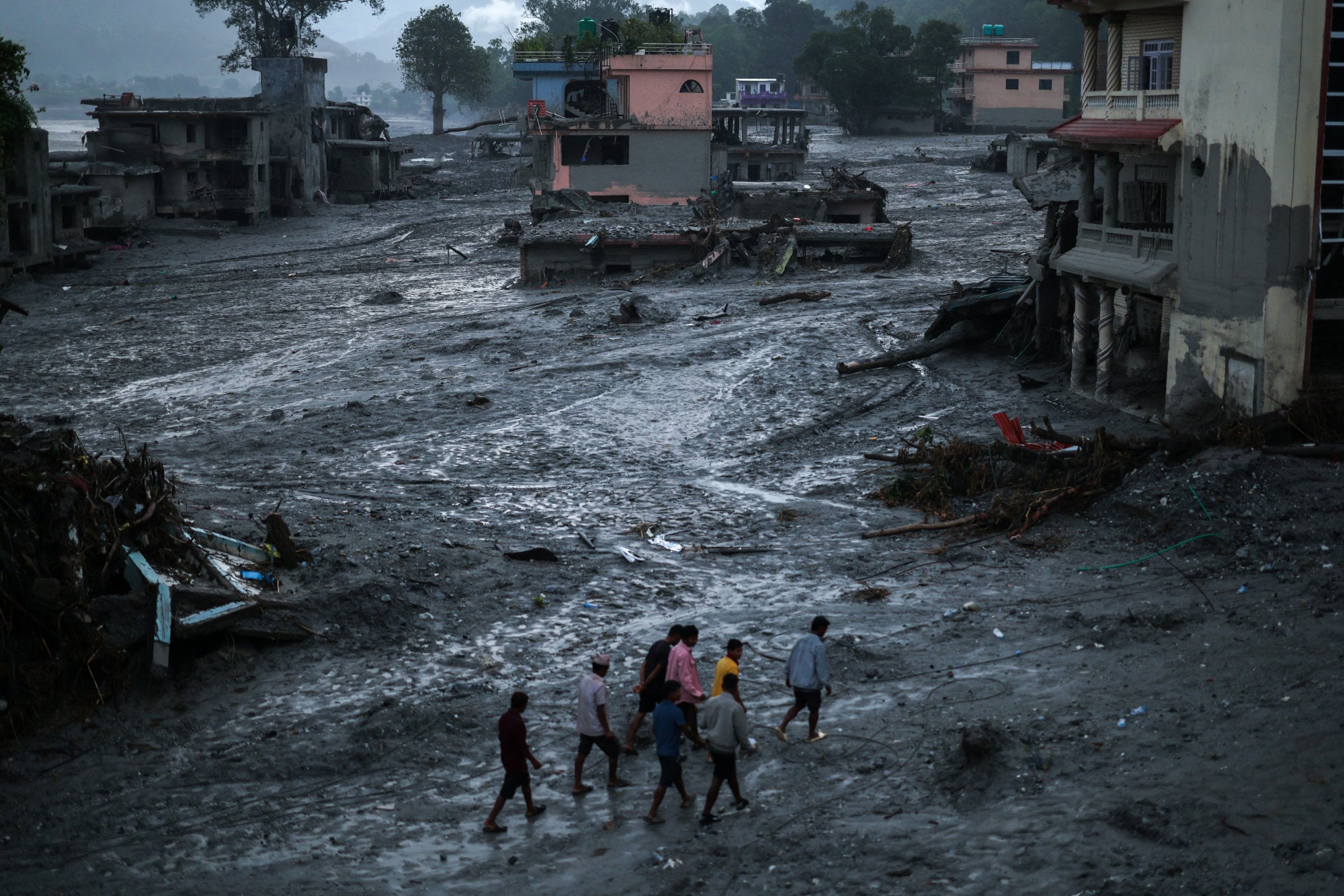 People walk next to damaged buildings in Nepal’s Nuwakot district. Photo: Reuters