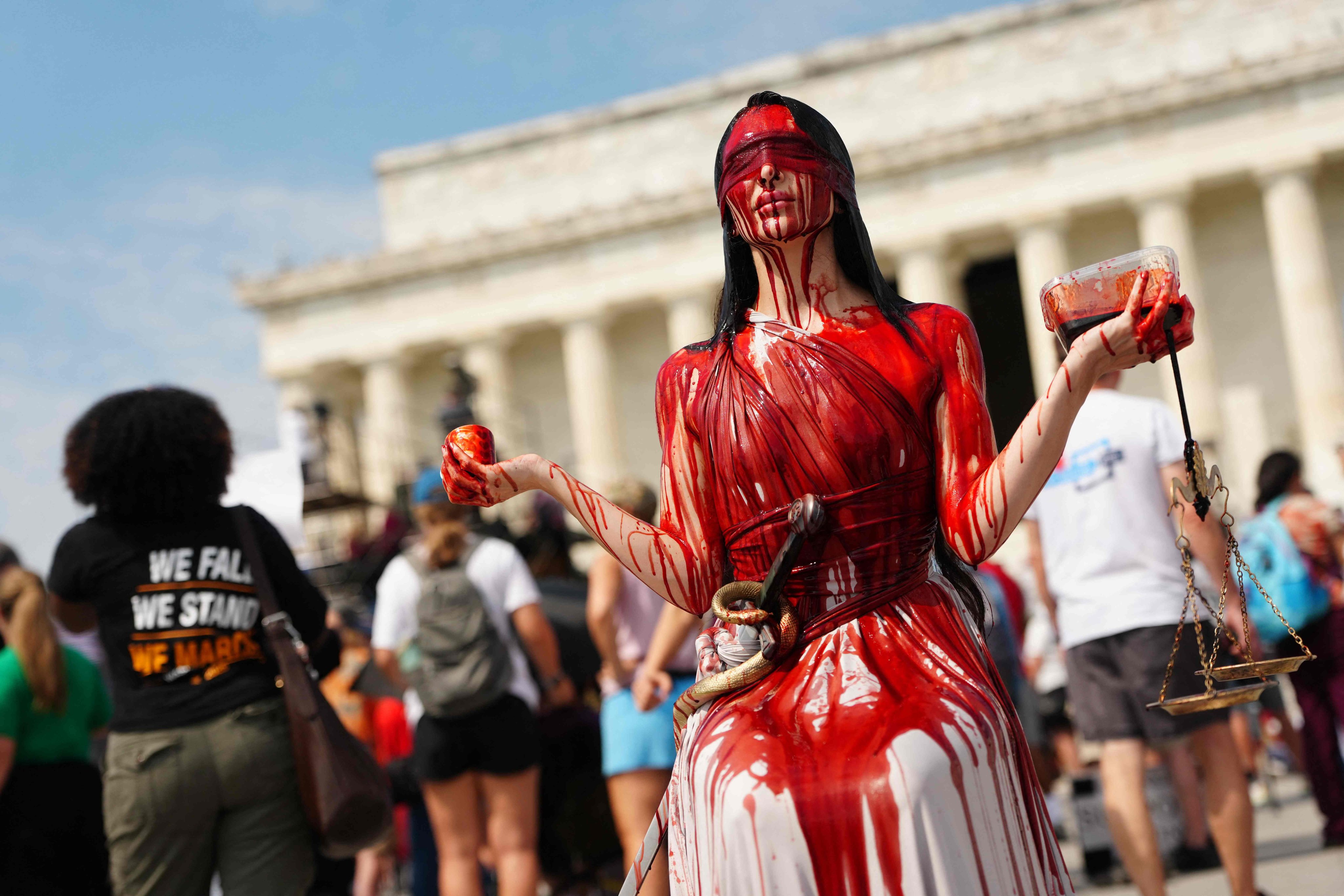 A demonstrator dressed as a blood-covered “Lady Justice” attends a “Defend the Vote” rally in Washington in August. Photo: AFP