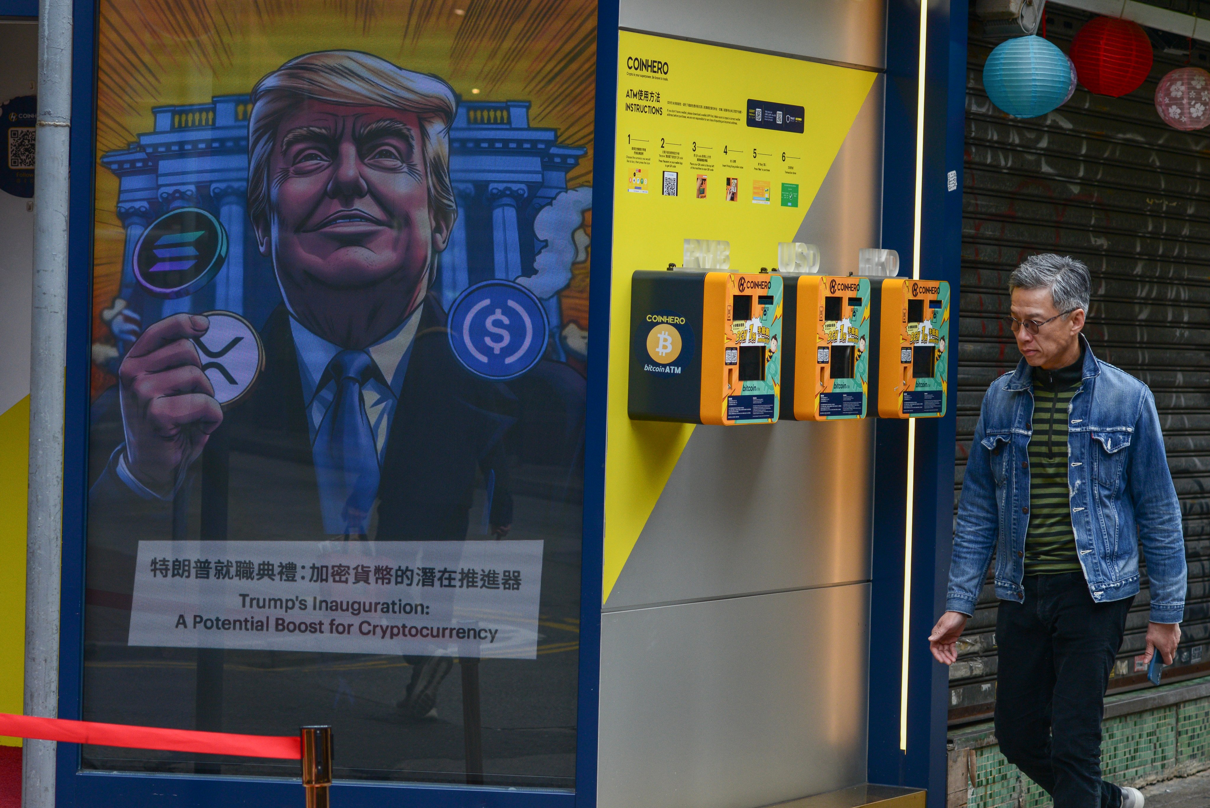 A resident walks past three cryptocurrency ATMs at the Coinhero flagship store in Causeway Bay. Photo: Antony Dickson