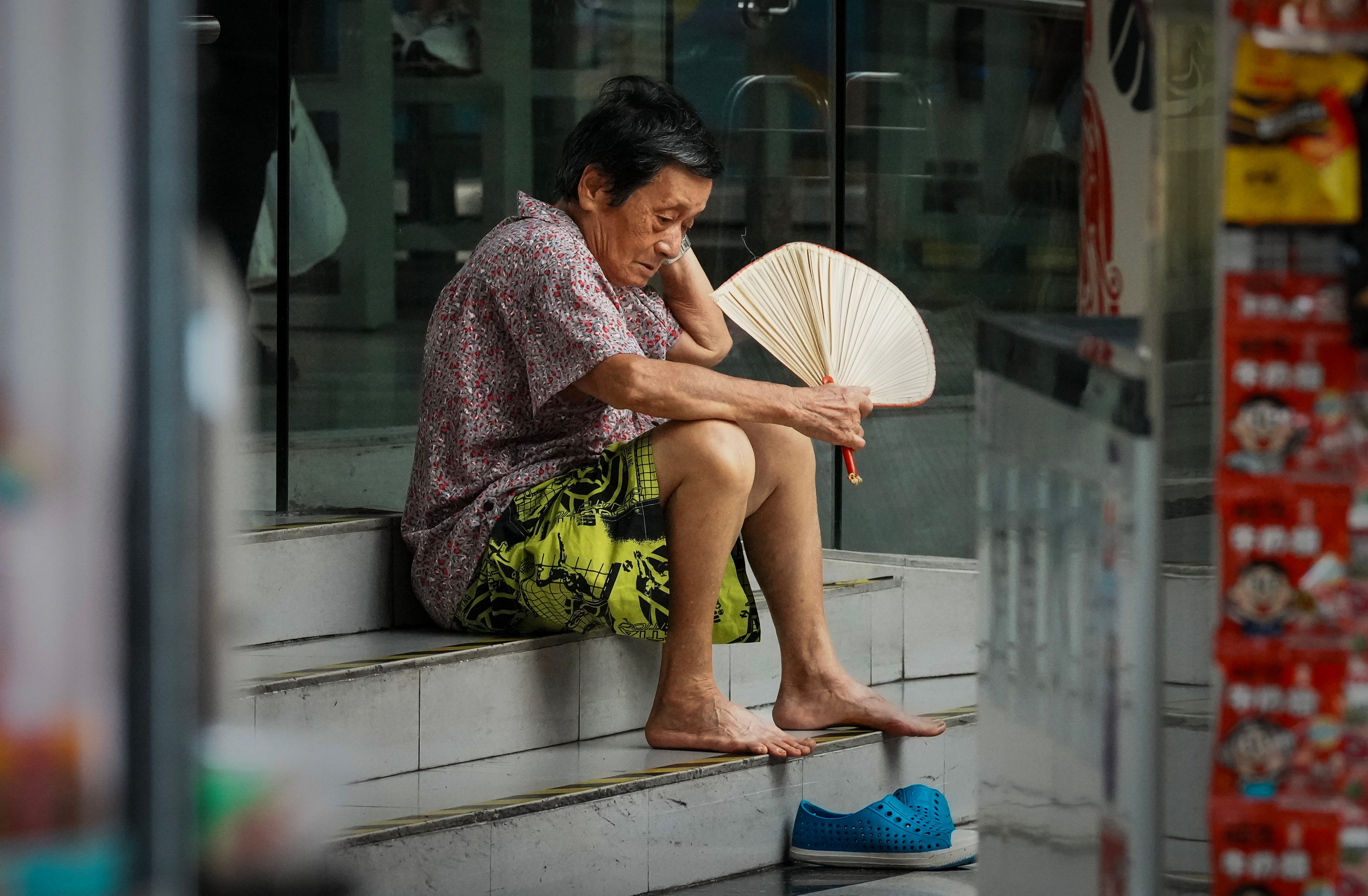 An elderly woman leaves her sweltering home to rest at a nearby air-conditioned shopping mall in Sham Shui Po on August 24. Photo: Dickson Lee