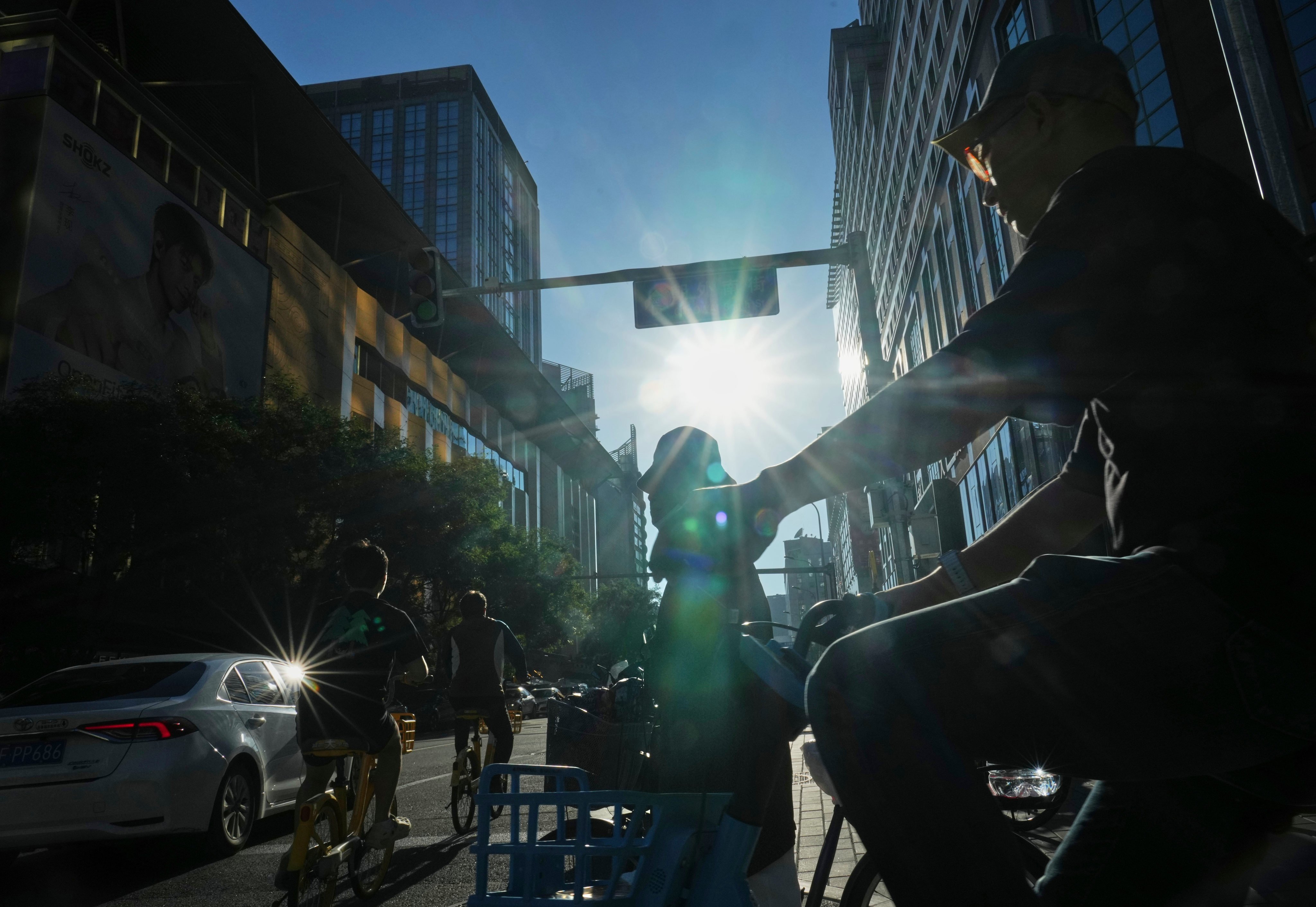 People ride bikes on a street in Beijing on August 29. The IMF projects that population ageing can cause China’s pension spending to rise by nearly 10 percentage points of GDP between 2024 and 2050. Photo: AP