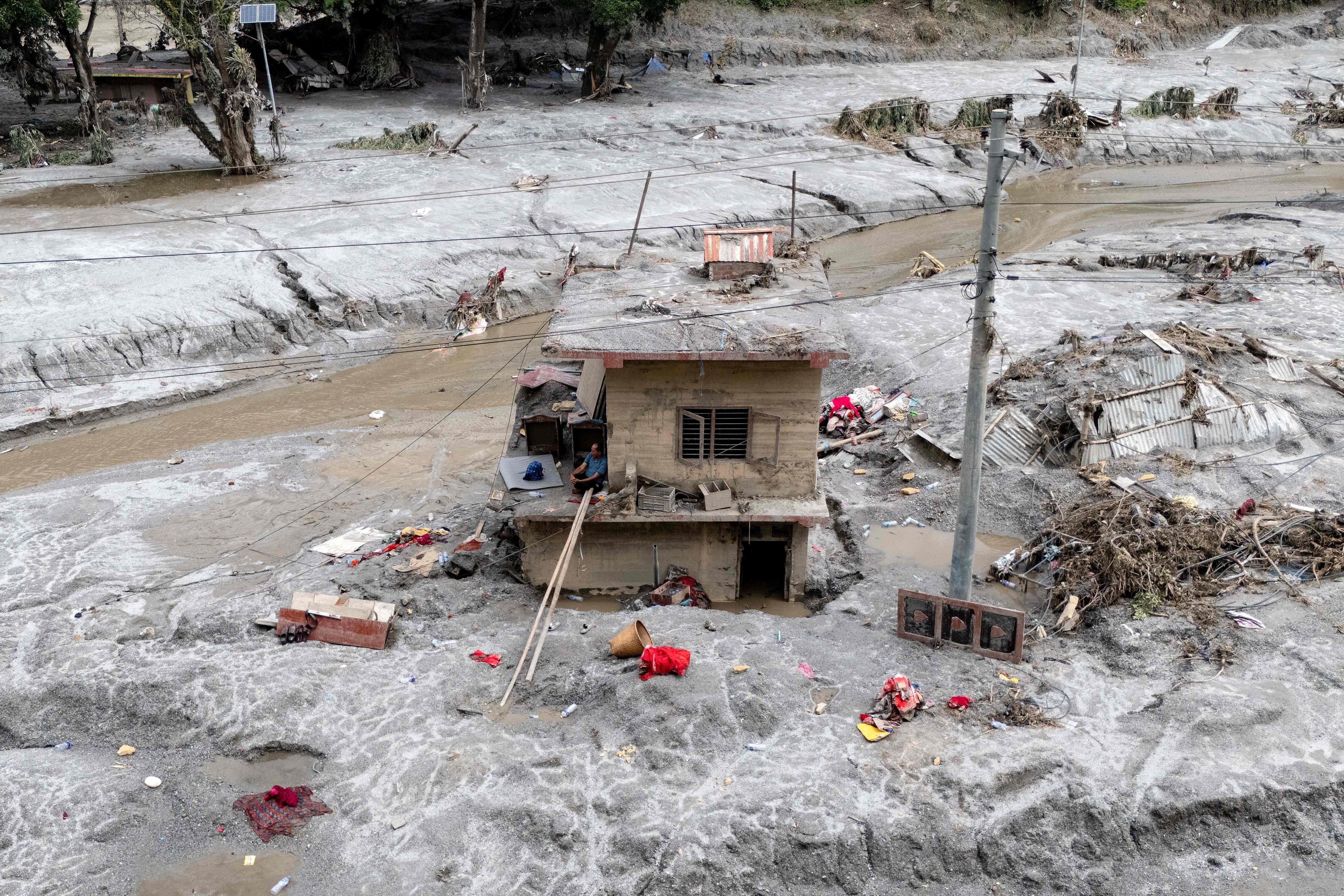 A man sits on the ledge of his damaged house on Wednesday, a week after the devastating flash floods at Baireni in Nepal’s Dhading district. Photo: AFP