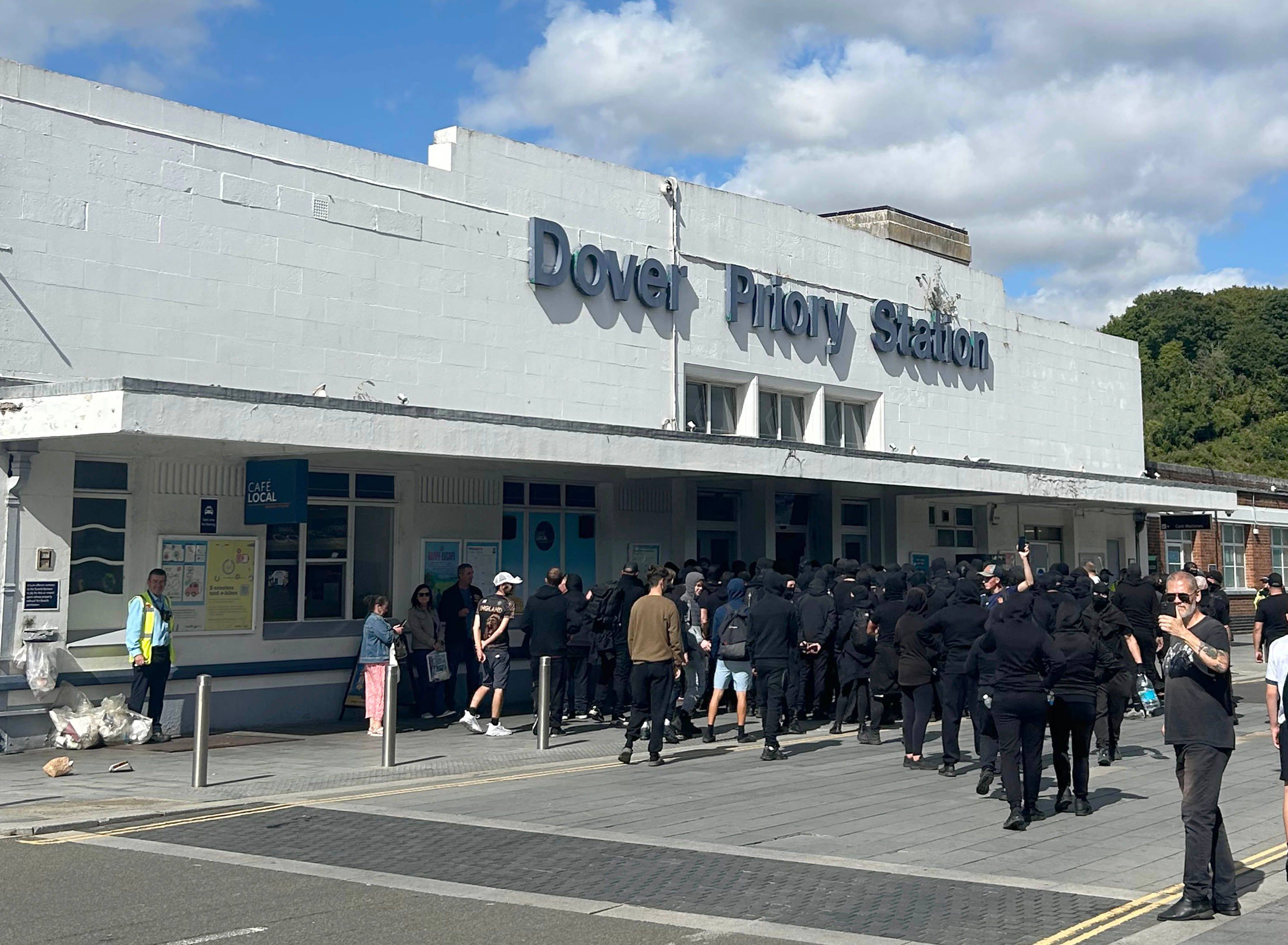 Black-clad and masked demonstrators gather at a train station after blocking roads in the UK port town of Dover. Photo: via dpa