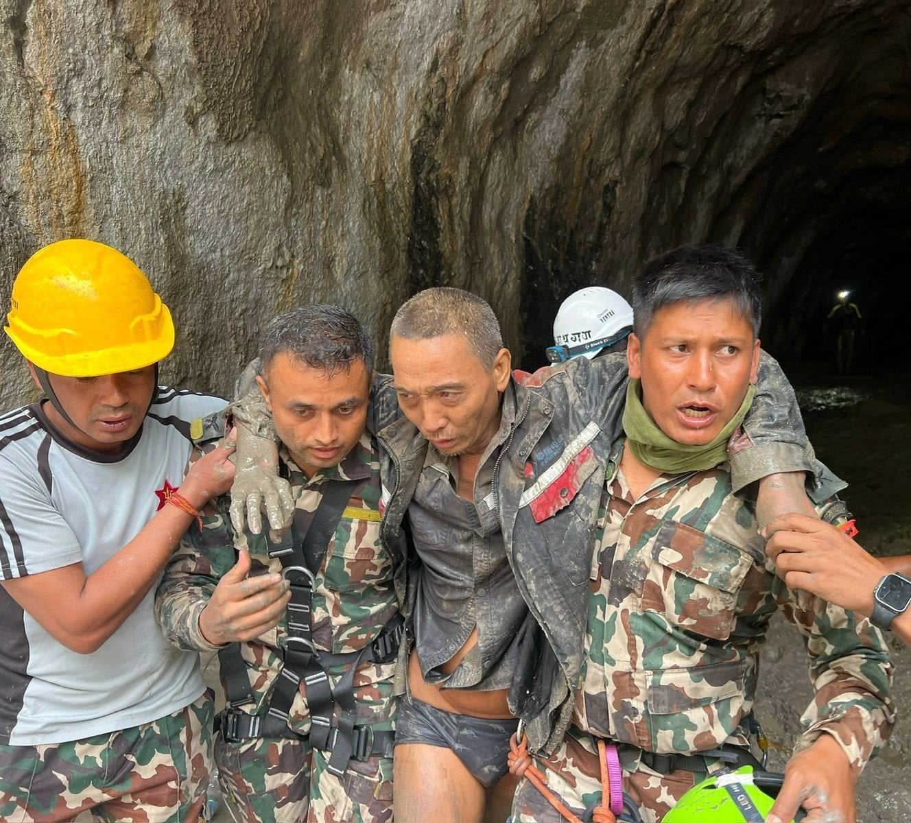 A Chinese man (second from right) was rescued from a tunnel in Nepal on Saturday, over a week after fatal flash floods devastated river valleys along the China-Nepal border. Photo: Army handout via EPA