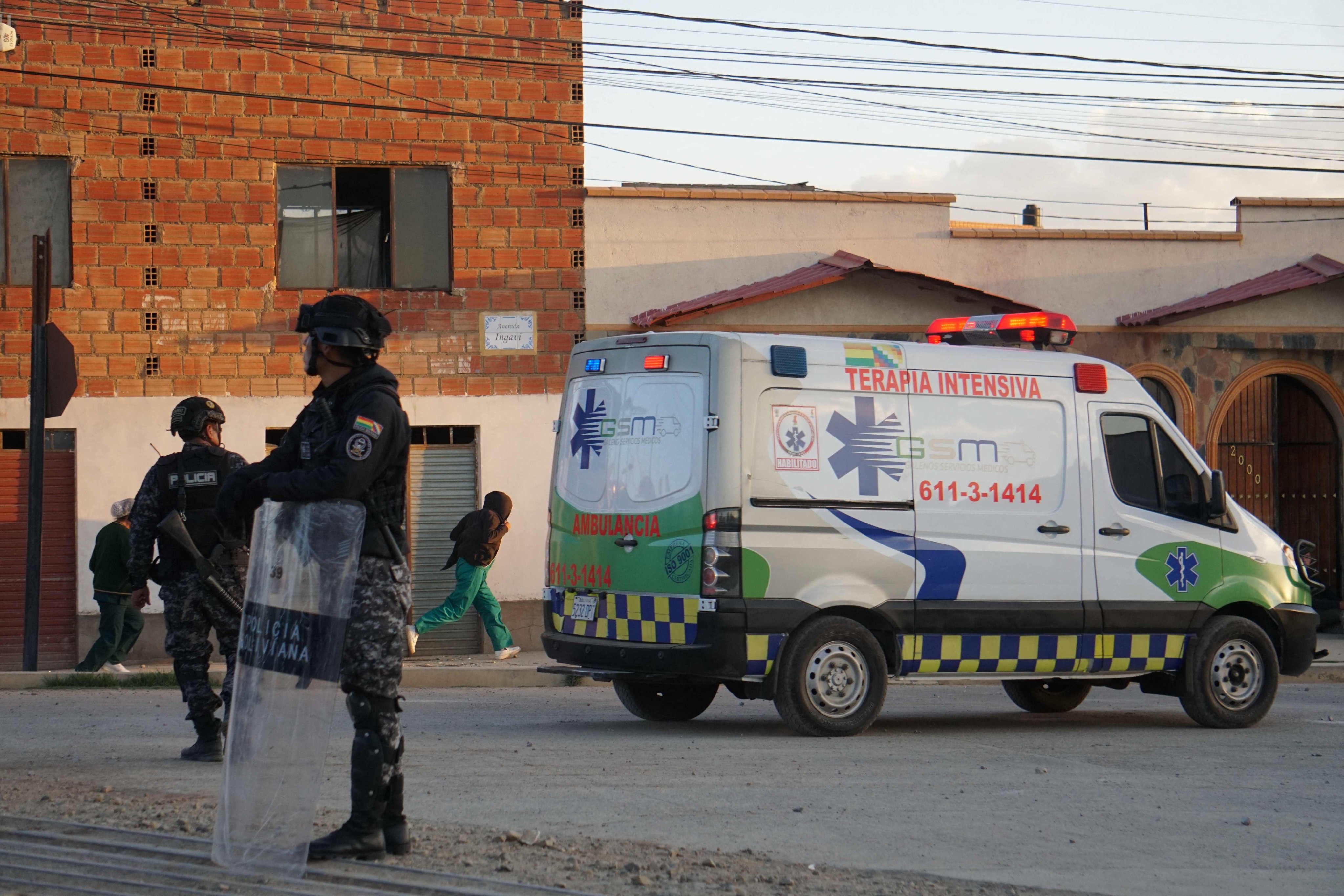 Police officers standing near an ambulance at the site of an explosion at an army barracks in Viacha, Bolivia, on Friday. Photo: AFP
